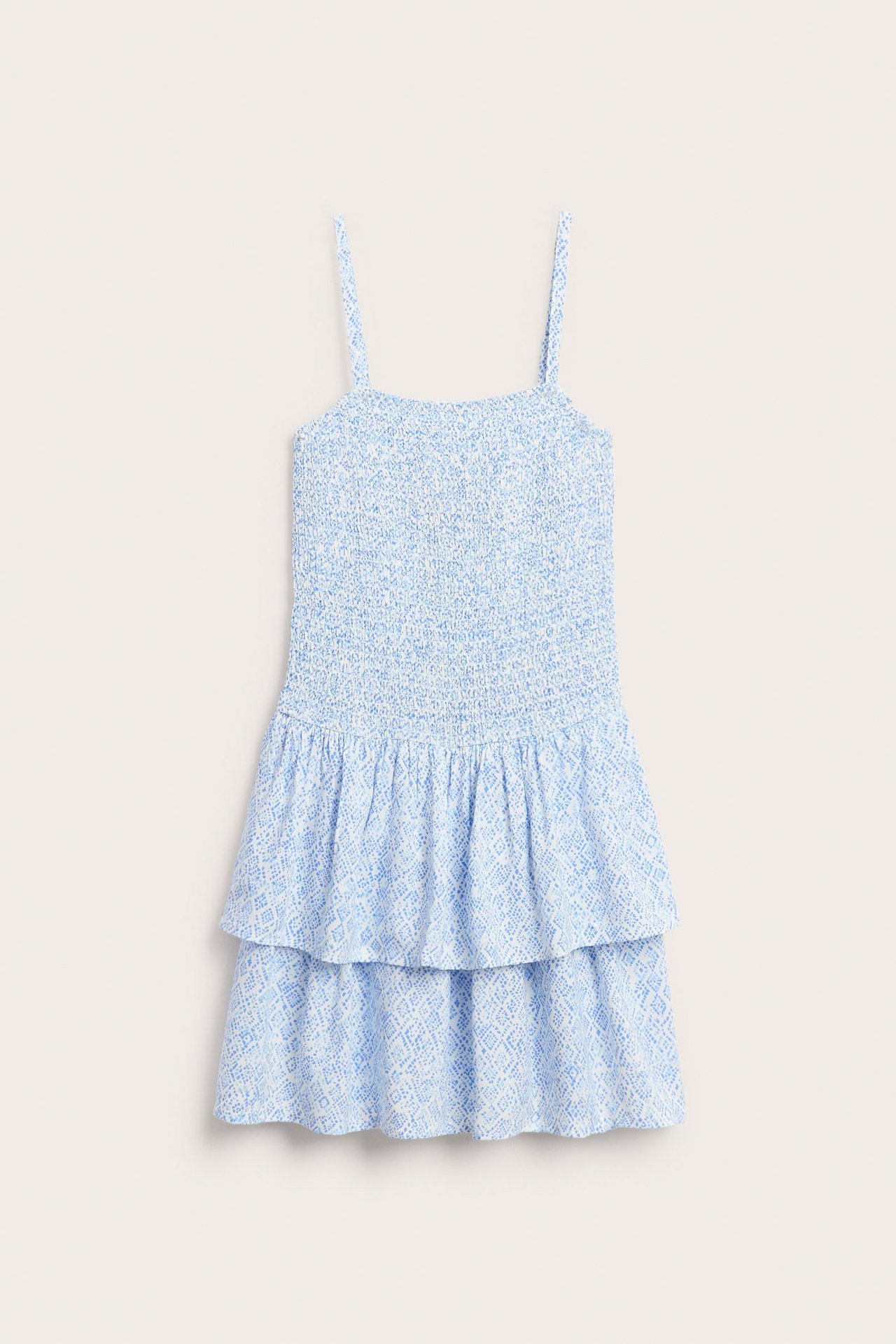 Widok z przodu: Biała krótka sukienka z jasnoniebieskim wzorem, marszczona góra, cienkie ramiączka, falbaniasta spódnica.