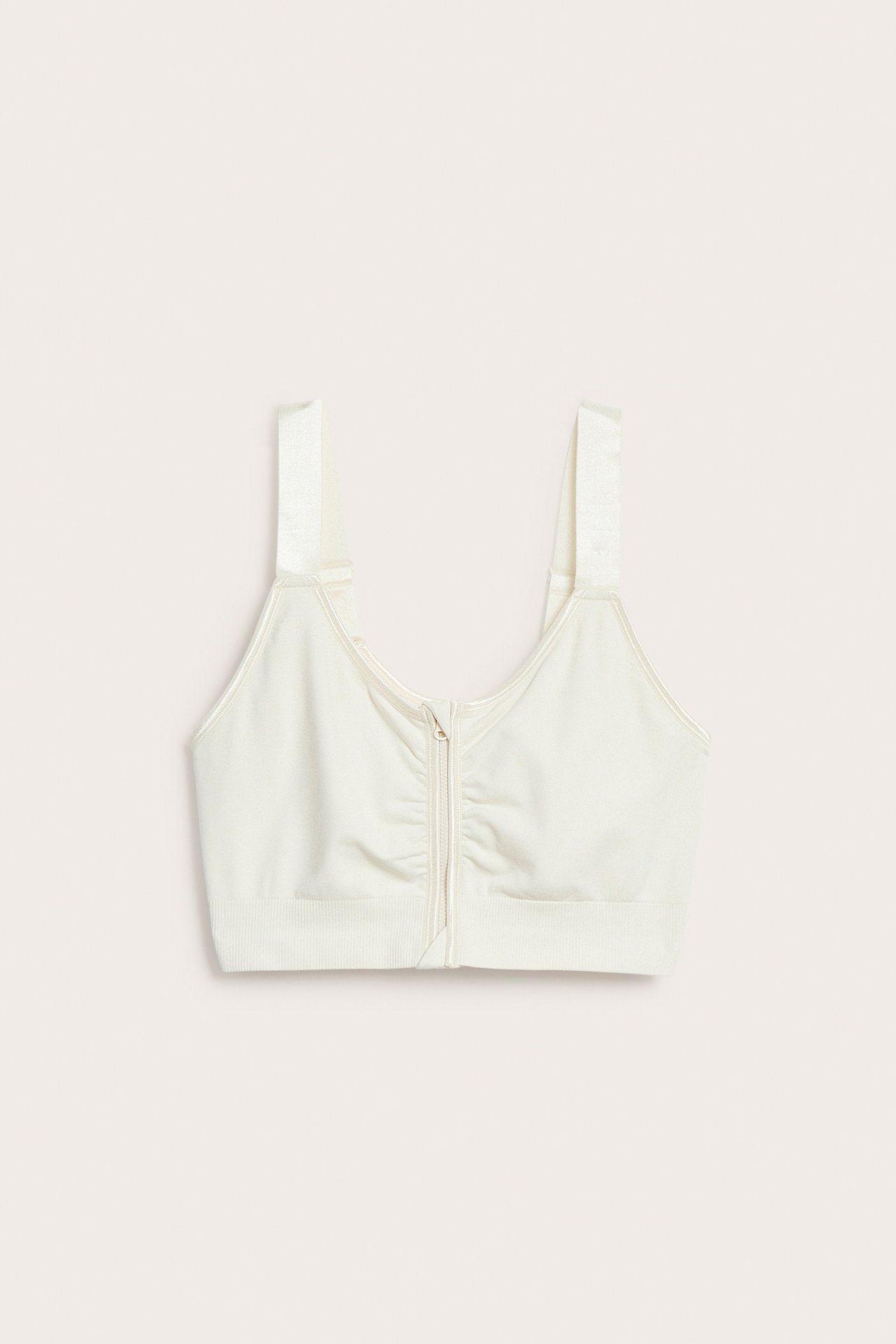 Forfra, offwhite sømløs bøylefri BH med brede stropper og glidelås foran.