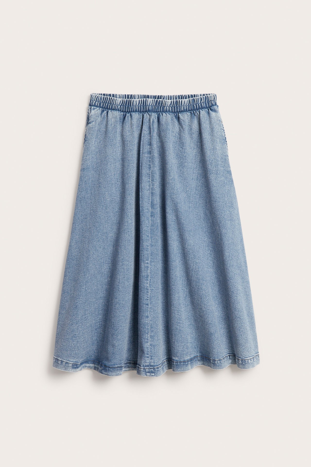 Frontbilde av et lyseblått midilangt denimskjørt med elastisk midje og sidelommer.