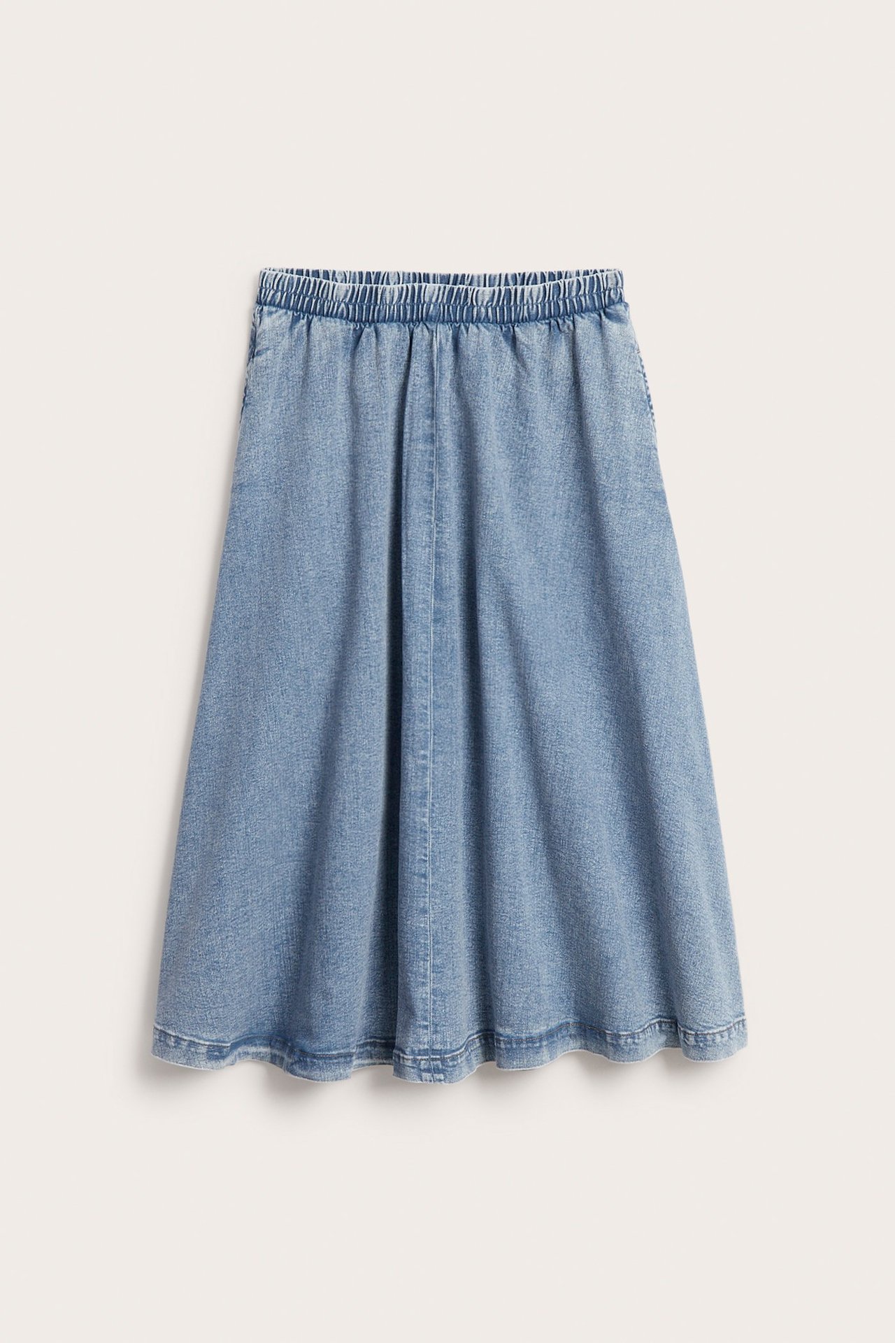 Frontbilde av et lyseblått midilangt denimskjørt med elastisk midje og sidelommer.