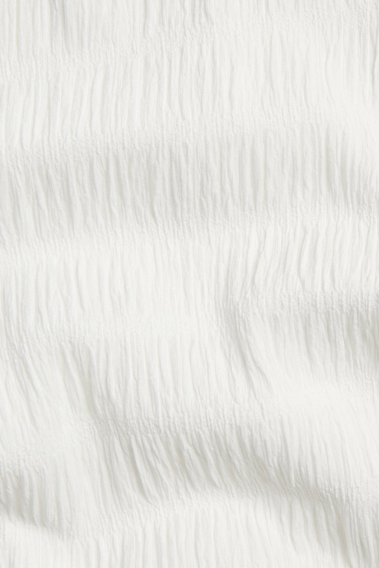 Nærbilde av offwhite strukturert polyester-elastan-stoff med et subtilt vertikalt krøllet mønster.