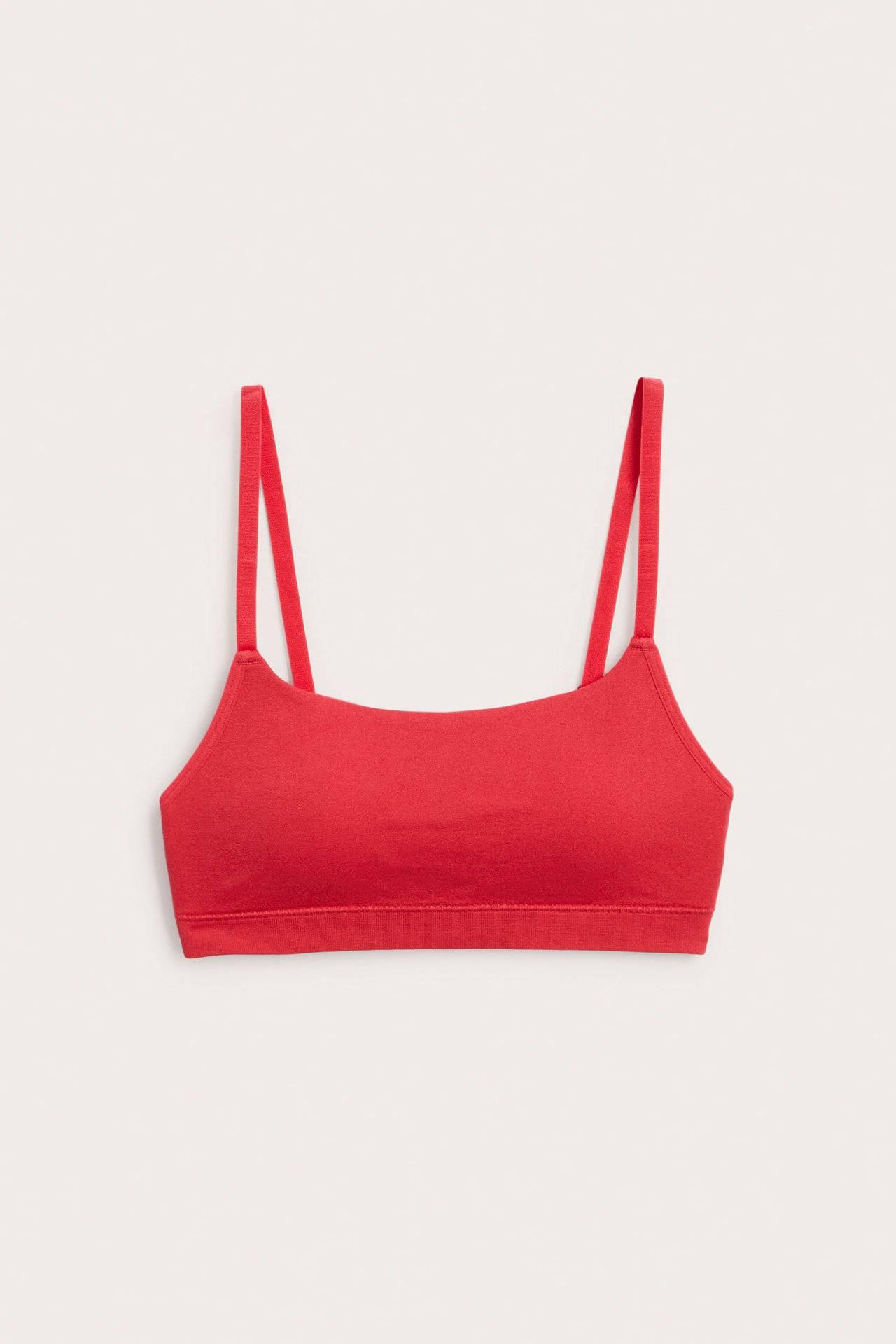 Edestä näkymä punaisista saumattomista rintaliiveistä ohuilla, säädettävillä olkaimilla.