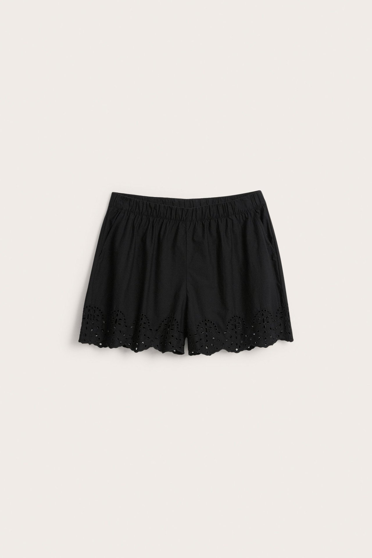 Forfra: Svarte shorts i bomullspoplin med elastisk linning, sidelommer og broderie anglaise-kant.
