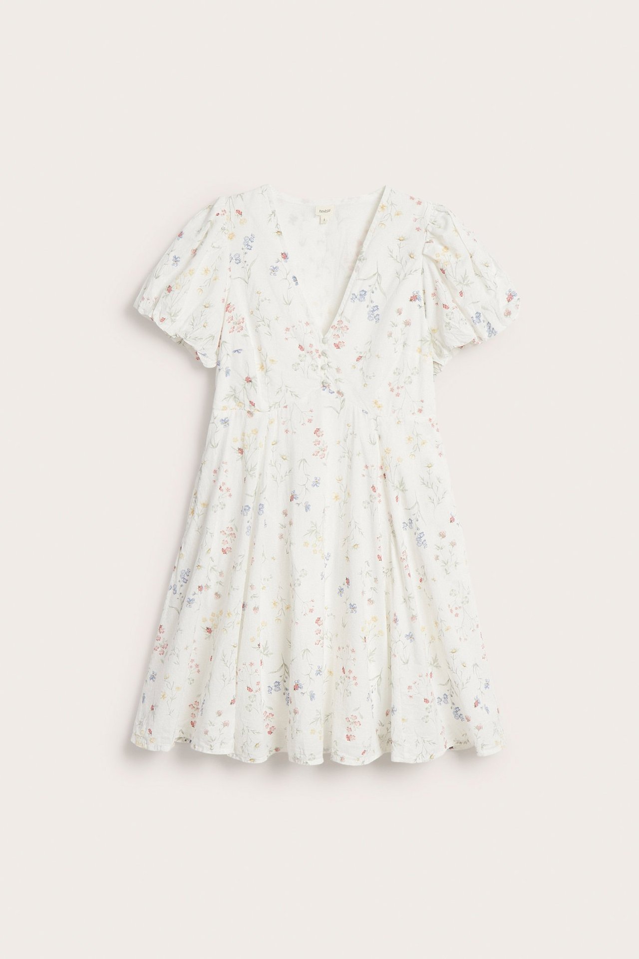 Framsida av en benvit blommig kort bomullsklänning med V-ringning och korta puffärmar.