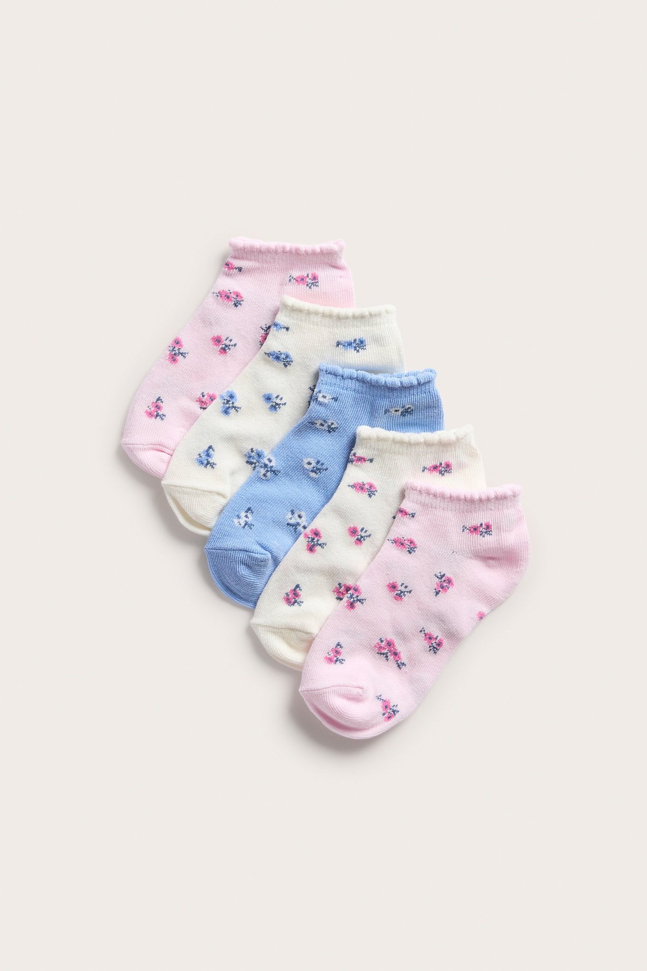 Widok z góry na pięć kwiecistych skarpetek stopki w kolorze różowym, ecru i niebieskim.