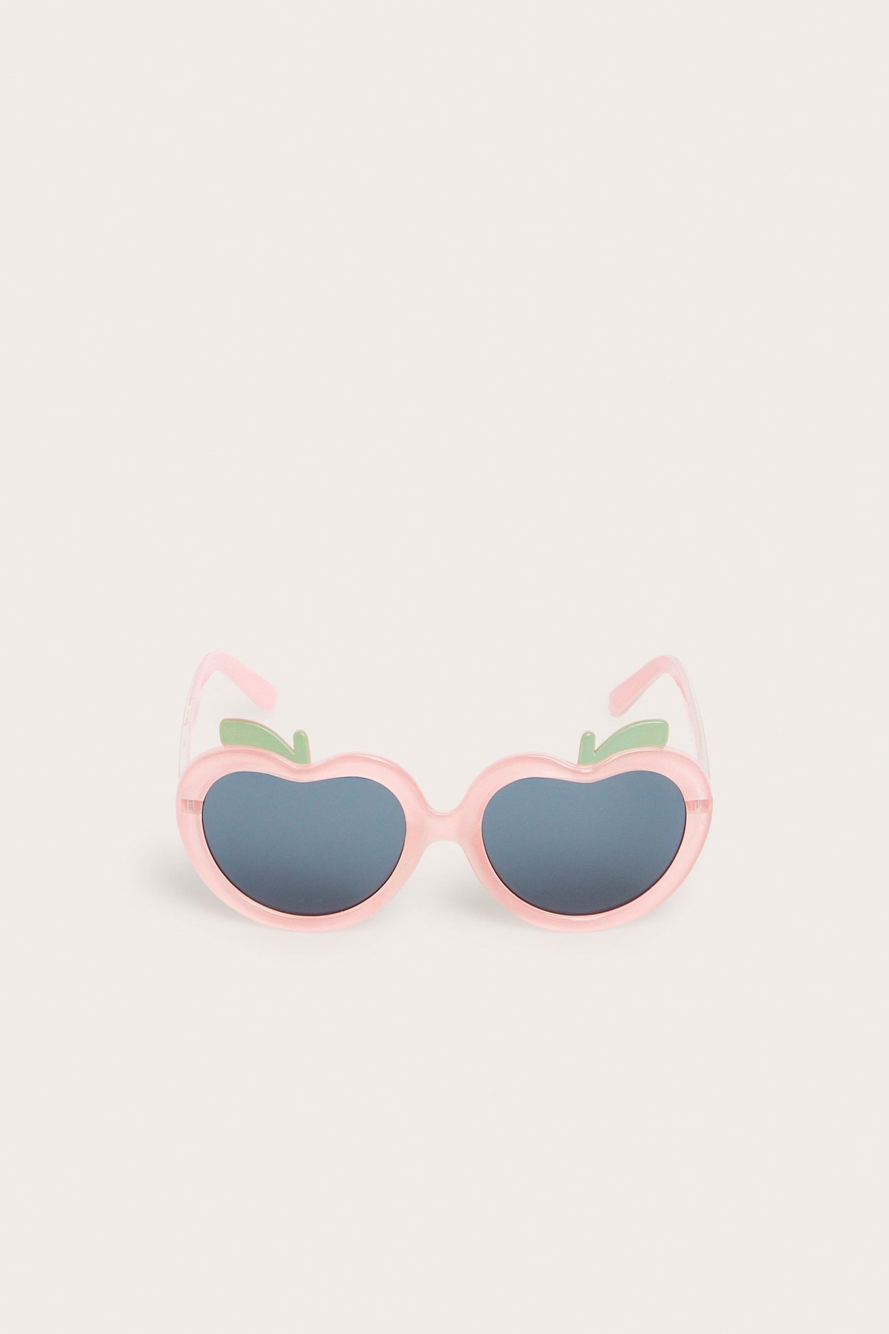 Frontvy av rosa plastsolglasögon i fruktform med mörka linser och gröna bladdetaljer.