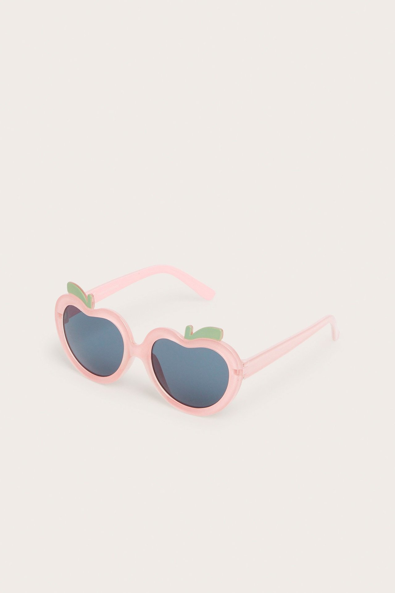 Rosa plastsolglasögon formade som frukter med mörka glas och små gröna blad, frontvy.