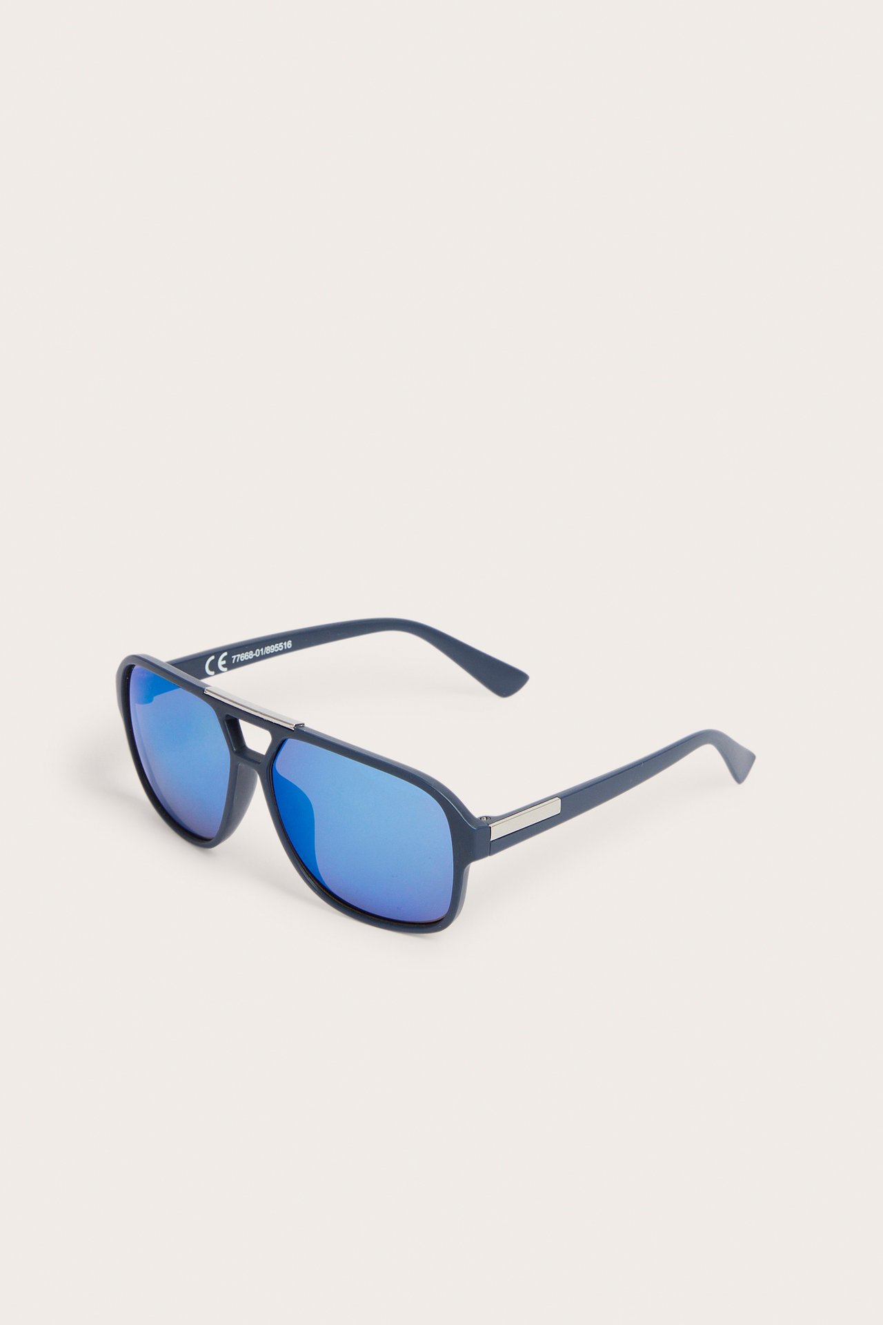 Skośny widok ciemnoniebieskich okularów pilotek z tworzywa z niebieskimi lustrzanymi soczewkami.