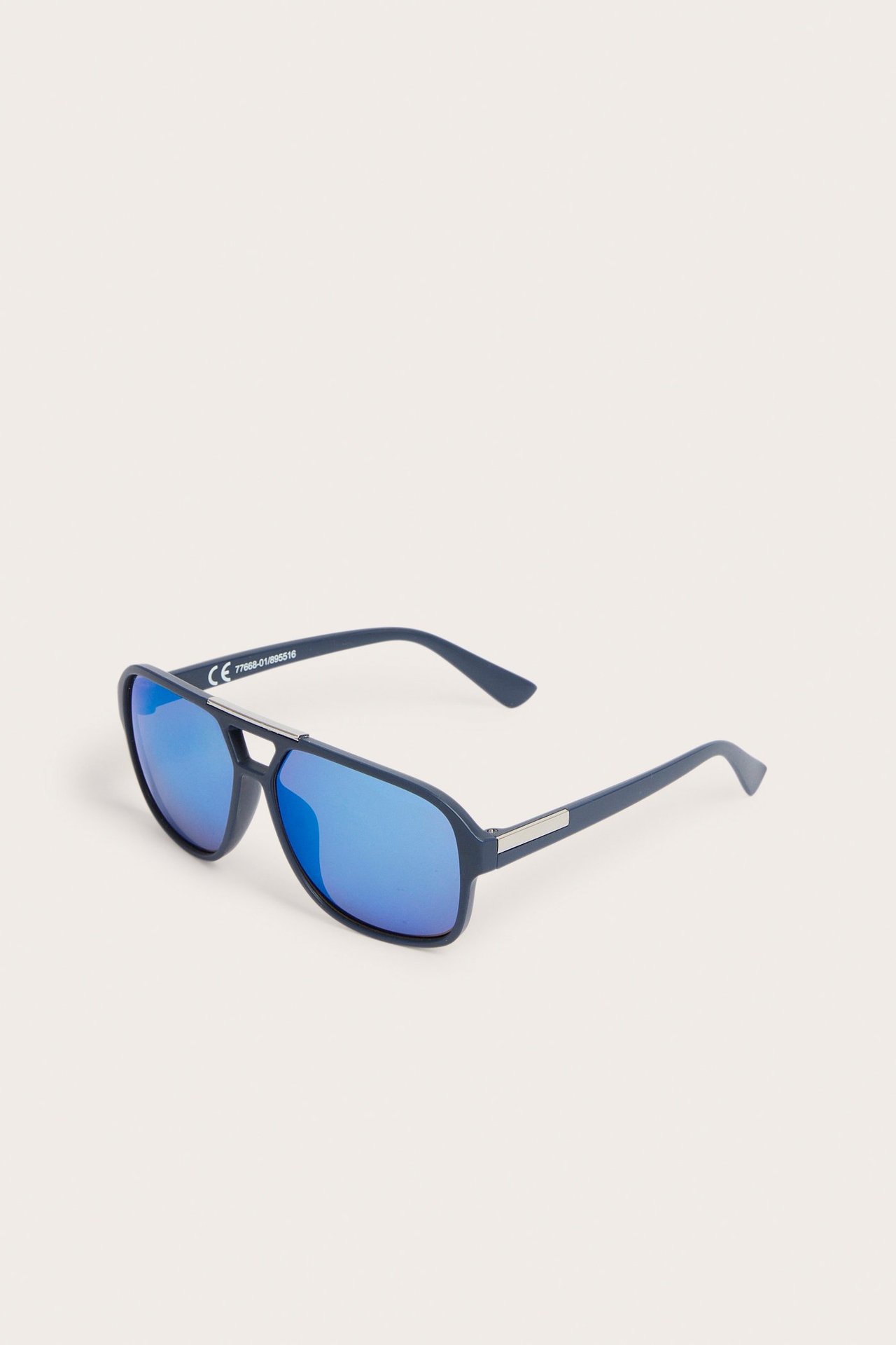 Skośny widok ciemnoniebieskich okularów pilotek z tworzywa z niebieskimi lustrzanymi soczewkami.