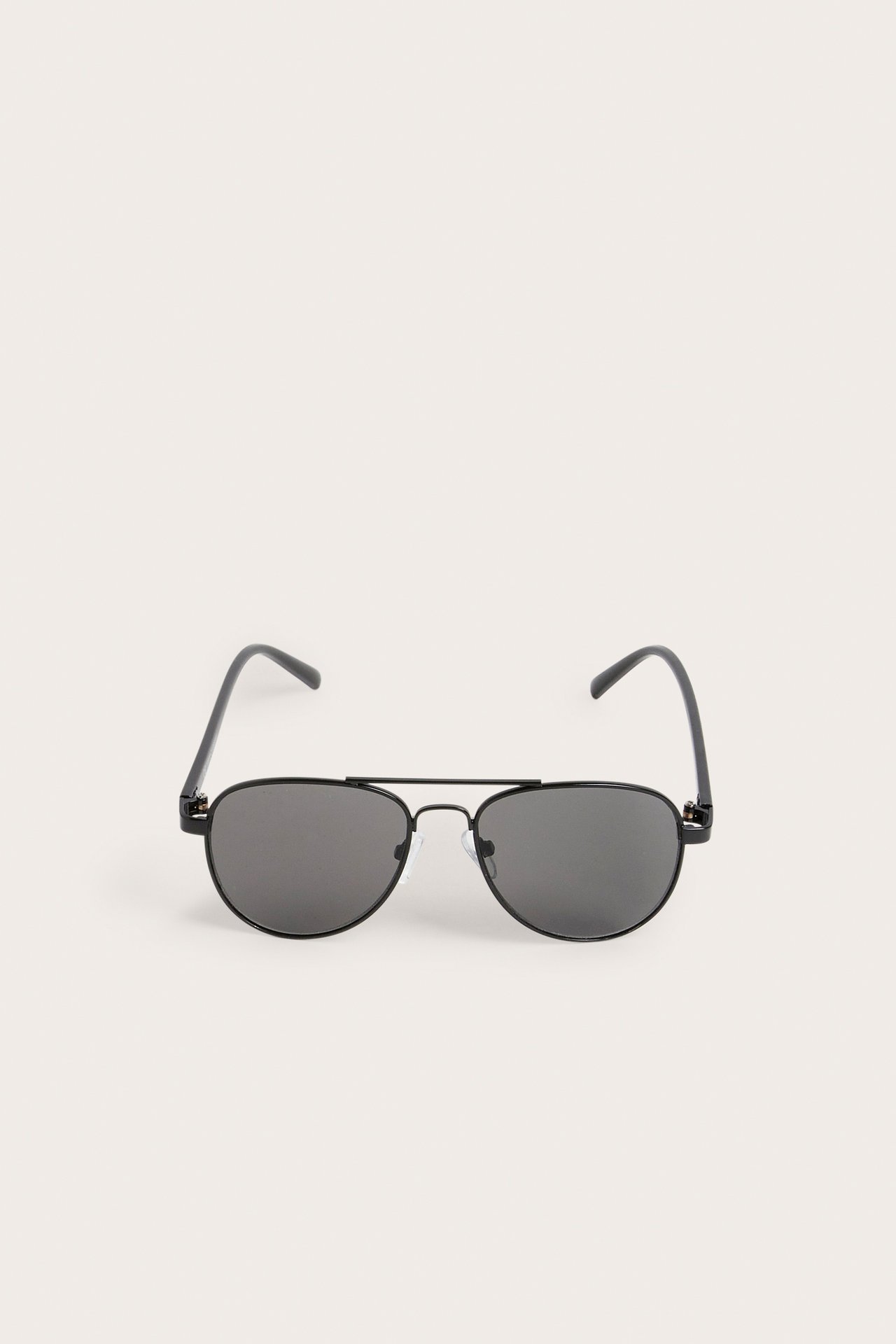 Widok z przodu czarnych metalowych okularów pilotek z ciemnymi soczewkami.