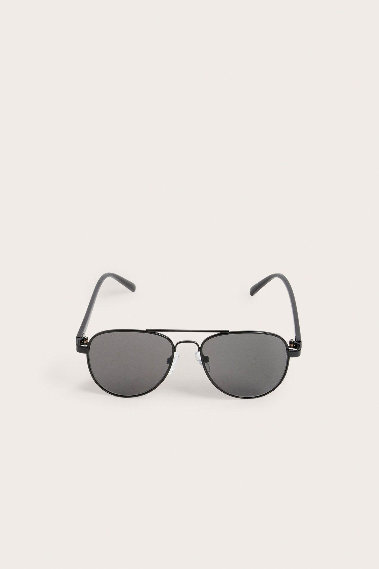 Widok z przodu czarnych metalowych okularów pilotek z ciemnymi soczewkami.