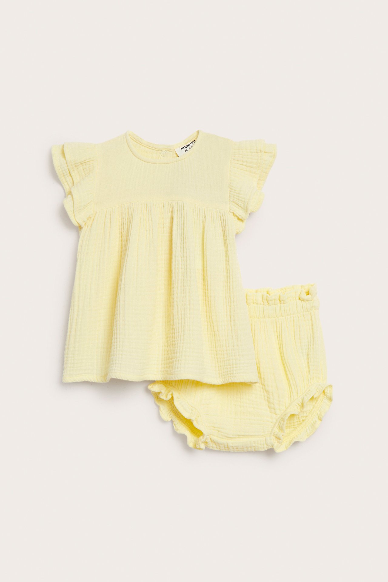 Edestä, vaaleankeltainen puuvillamysliininen vauvan setti, röyhelöhihainen toppi ja röyhelöbloomersit.