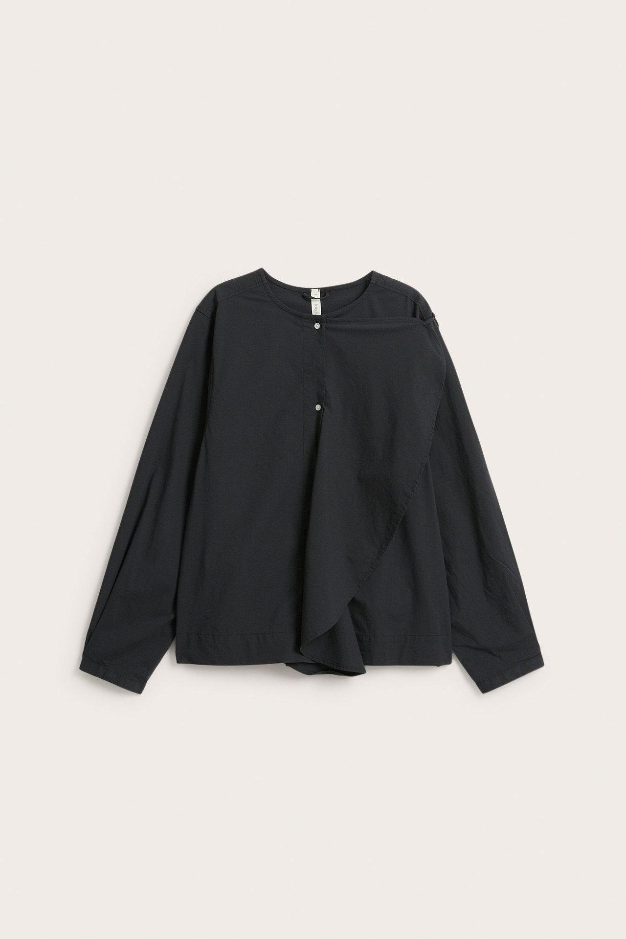Etunäkymä: Musta popliinipusero, jossa nauhakaulus, puolinappislista ja irrotettava olkarypytys.