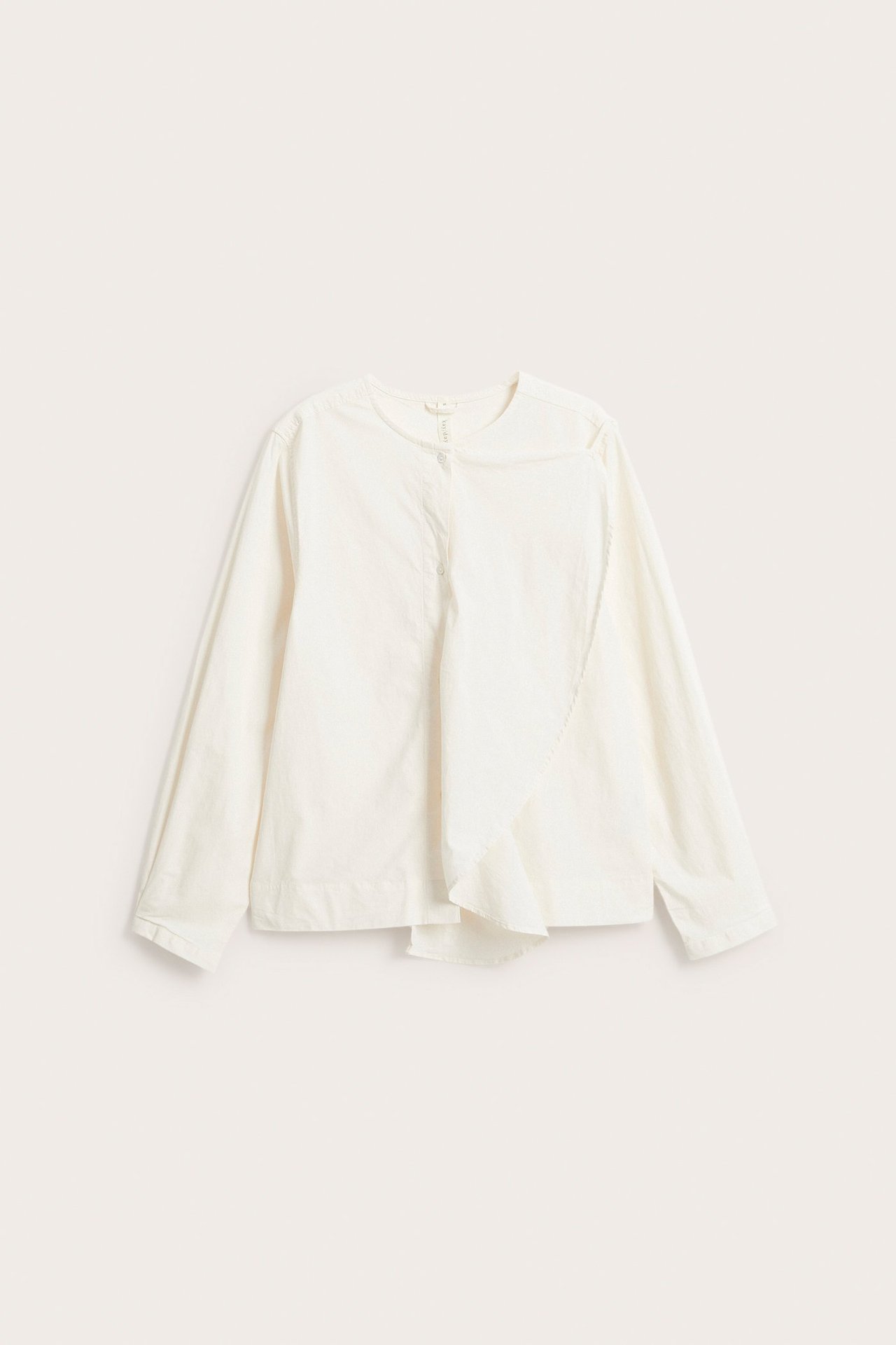 Edestä näkymä valkoisesta pitkähihaisesta popliinipuserosta, jossa pyöreä pääntie ja koristeellinen sivufrilla.