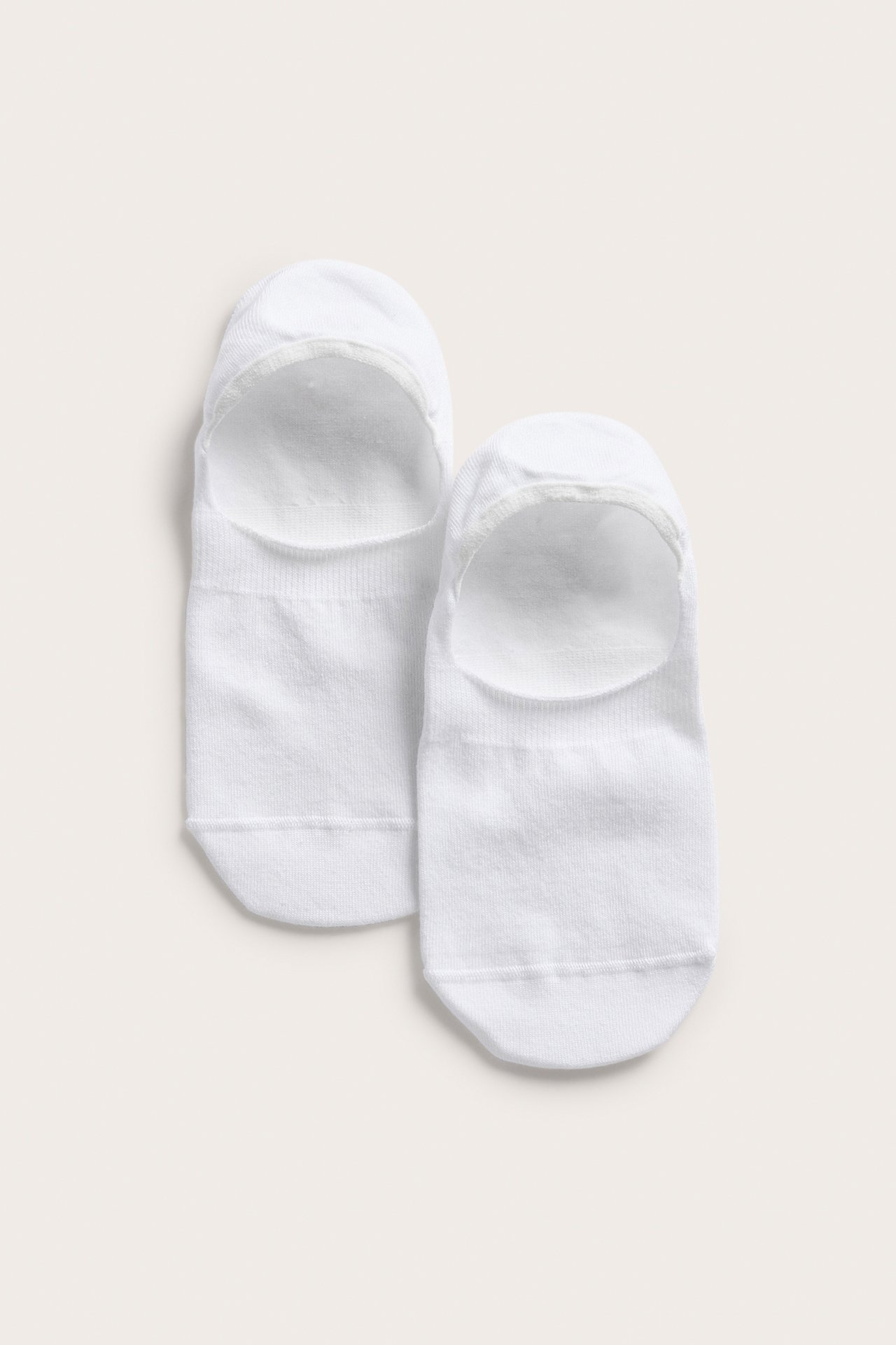 Platt bild framifrån av två vita enfärgade sneakerstrumpor i bomullsmix.