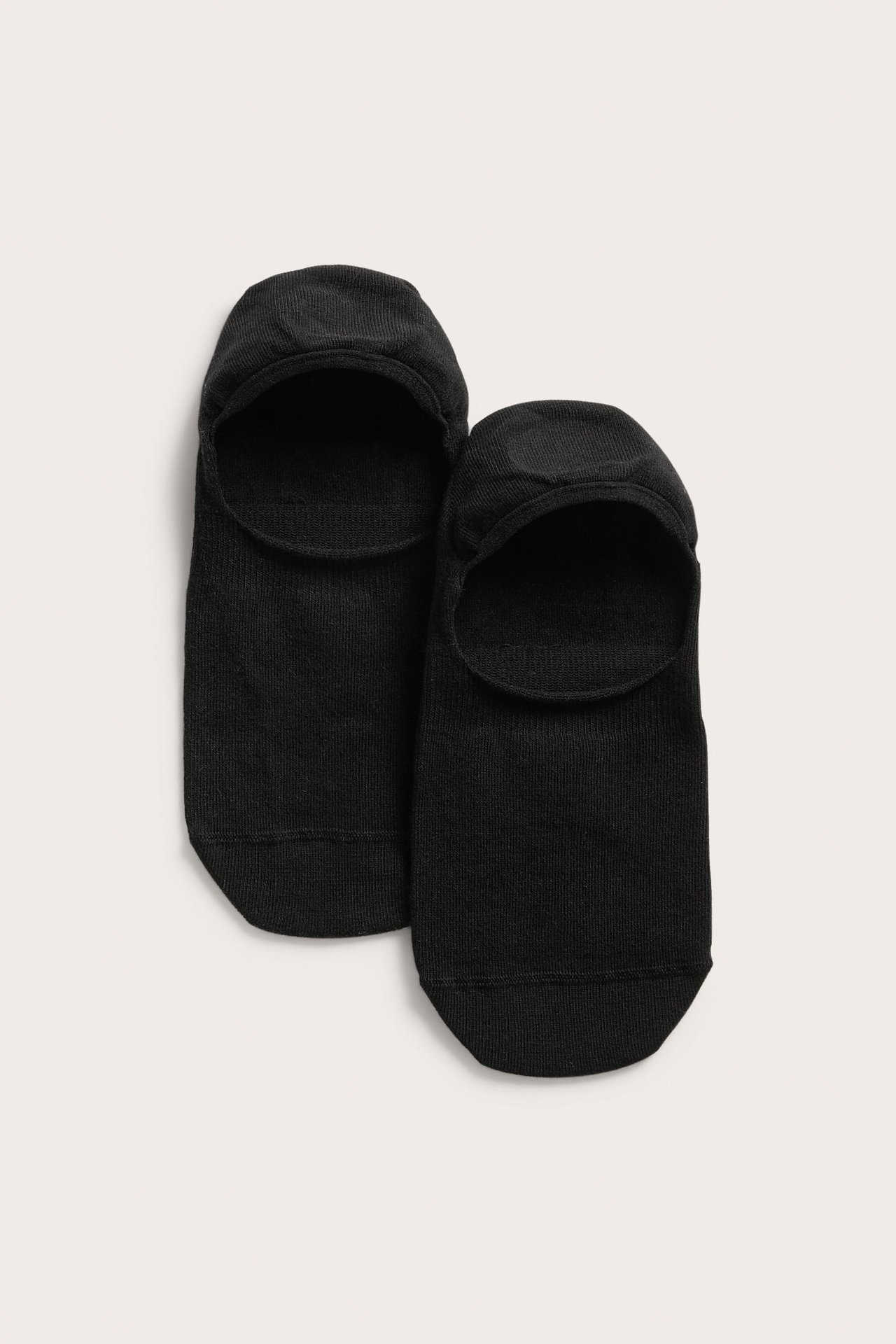 Topputsikt av to svarte ensfargede sneakersokker med silikongrep i hælen.