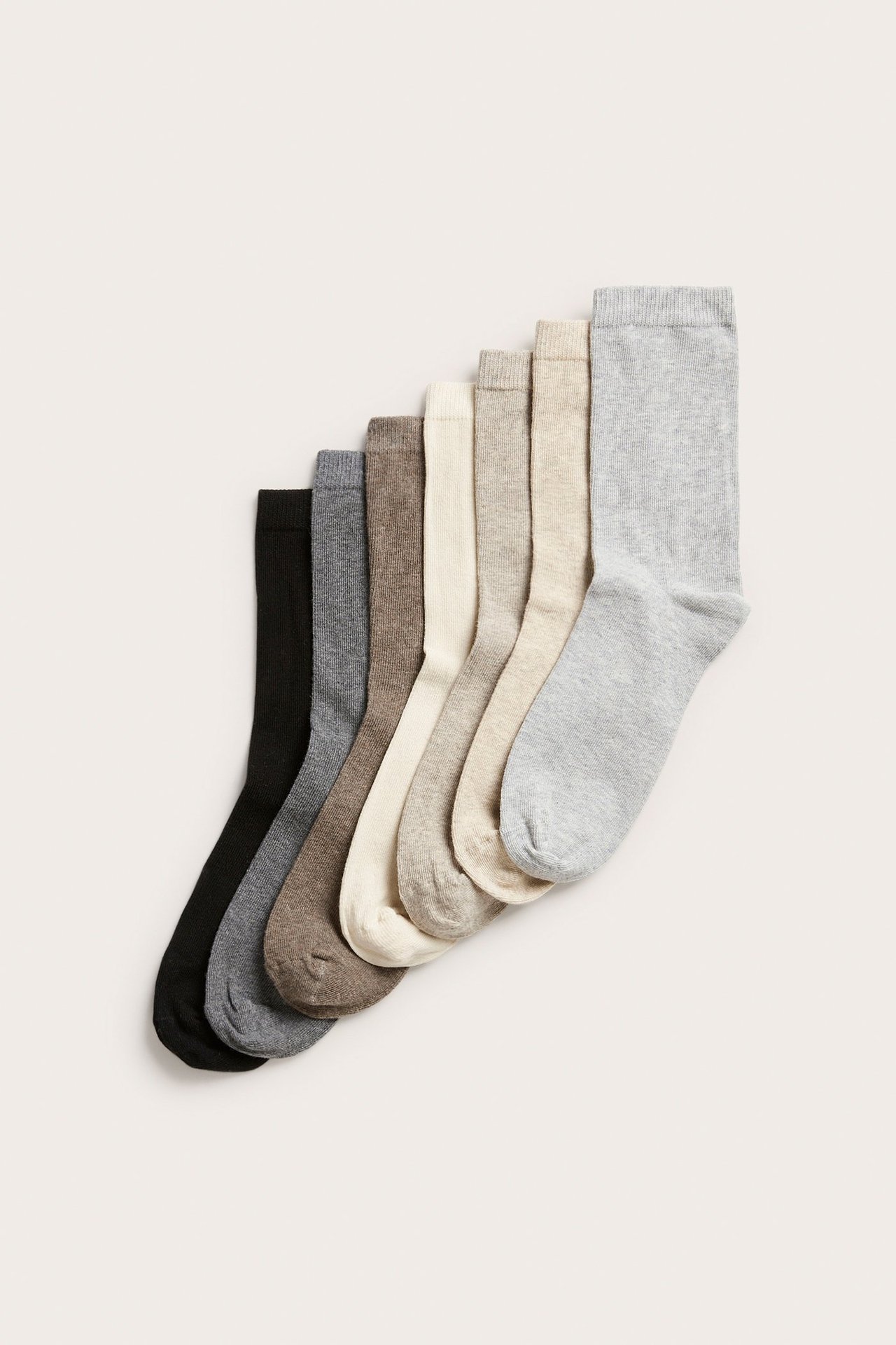 Ovenfra, syv par melerte sokker i bomullsblanding i nøytrale farger: beige, grå, brun, off-white, svart.