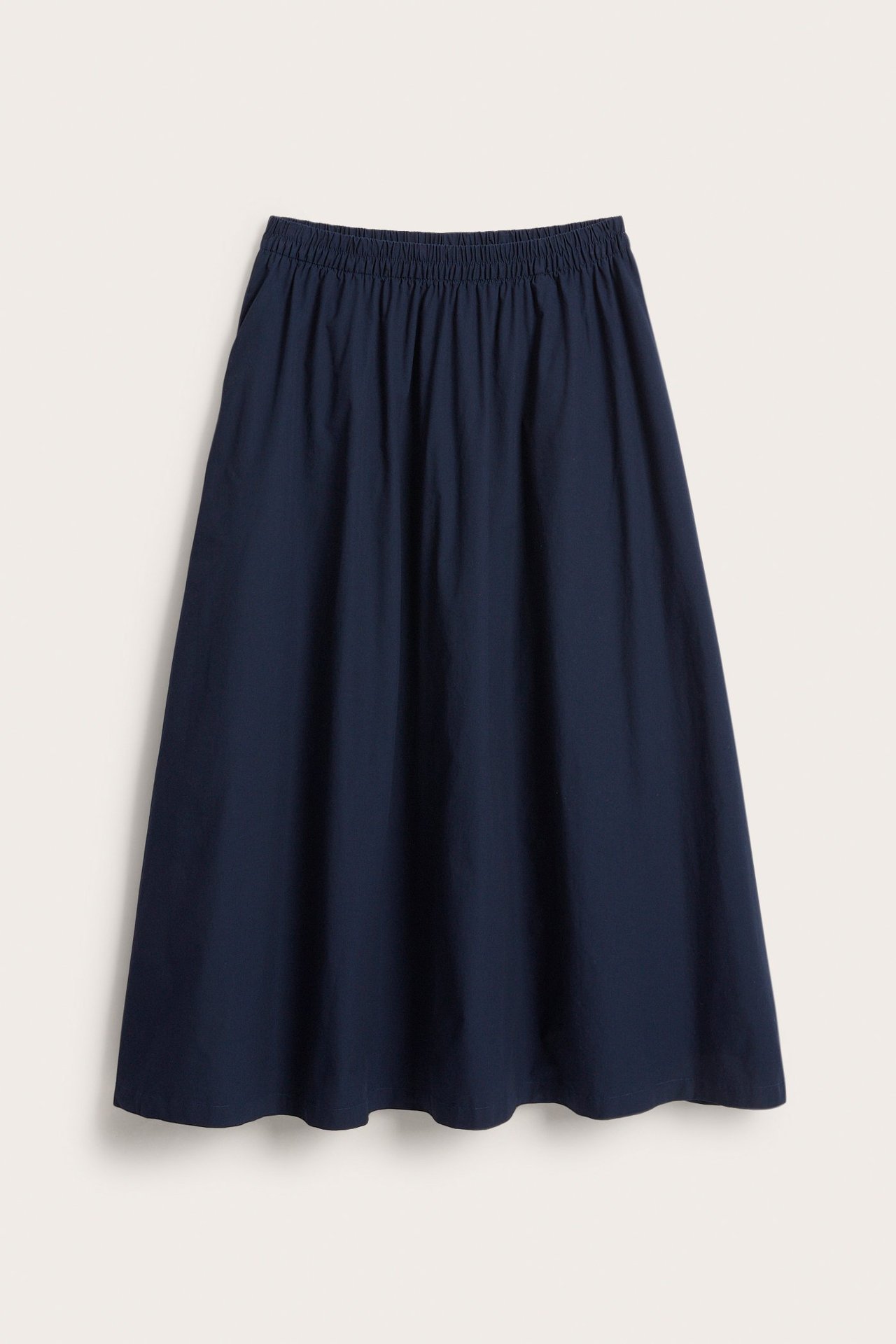 Frontvisning: Mørkeblått utsvingt skjørt i bomullspoplin med elastisk midje og sidelommer.