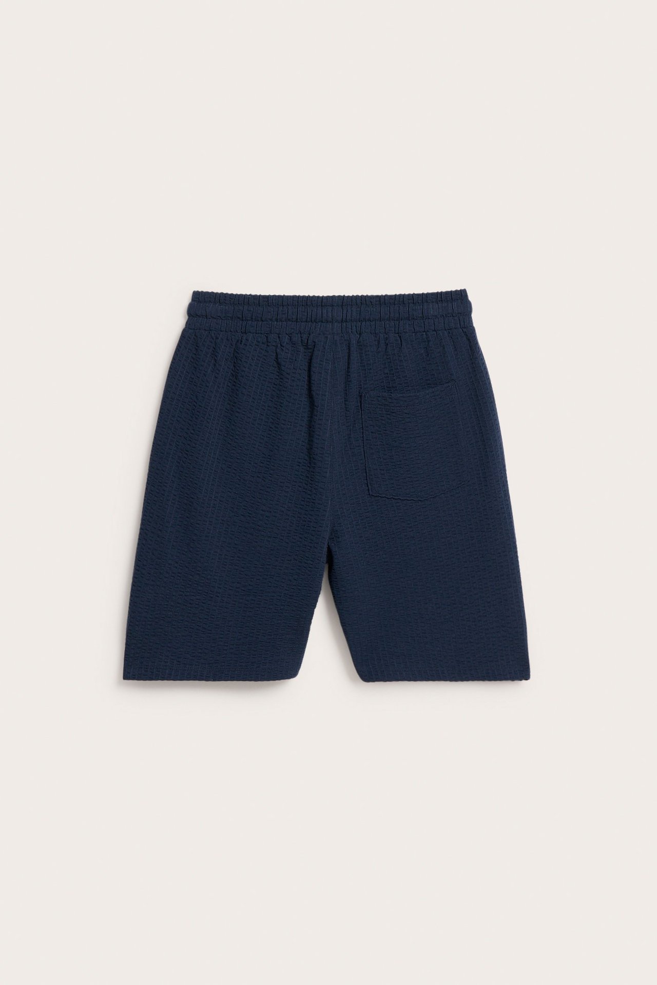 Widok z tyłu: ciemnoniebieskie szorty z dżerseju seersucker z elastyczną talią i tylną kieszenią.