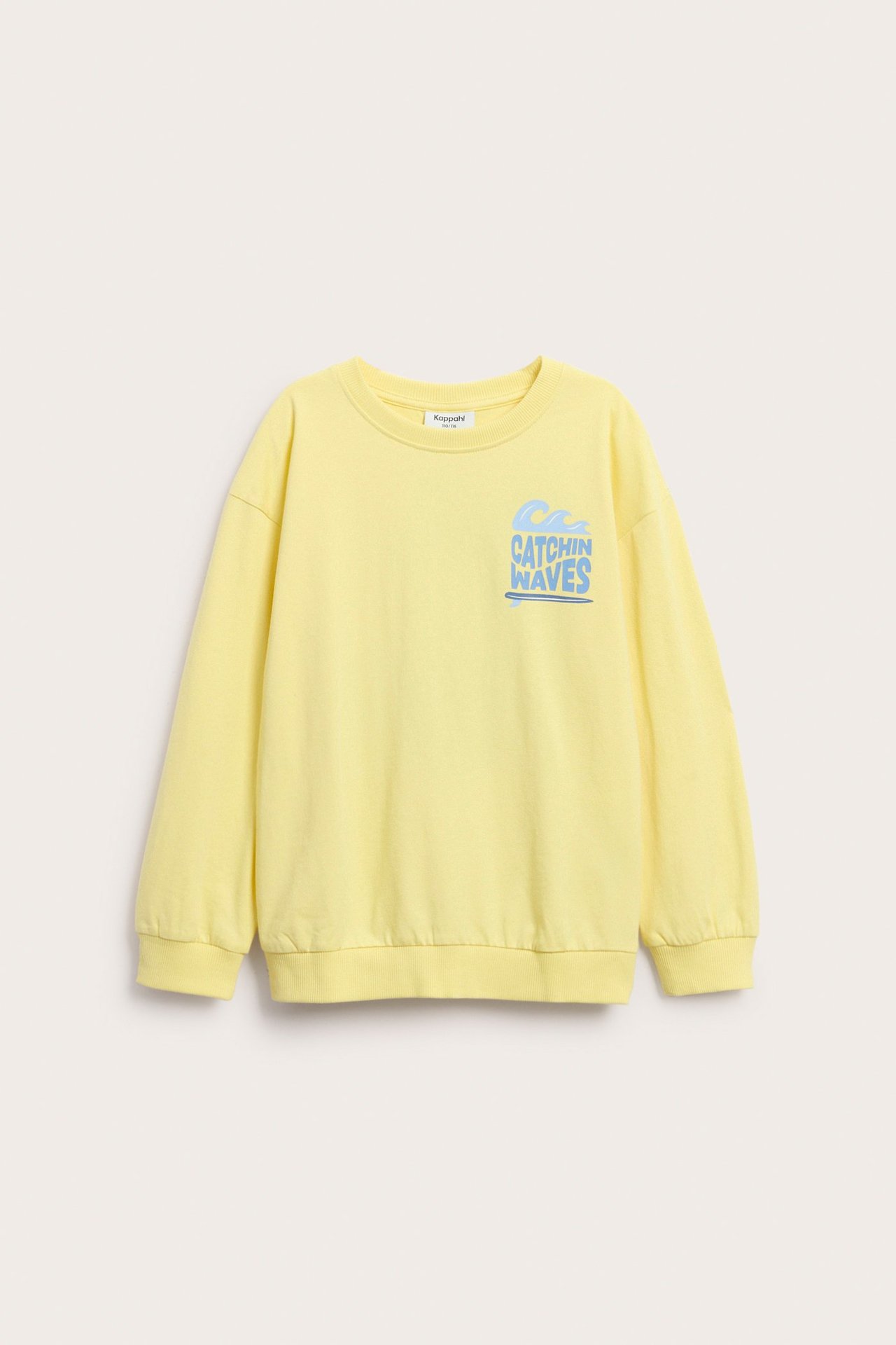 Widok z przodu żółtej bawełnianej bluzy dziecięcej z opuszczonymi ramionami i niebieskim nadrukiem "CATCHIN WAVES".