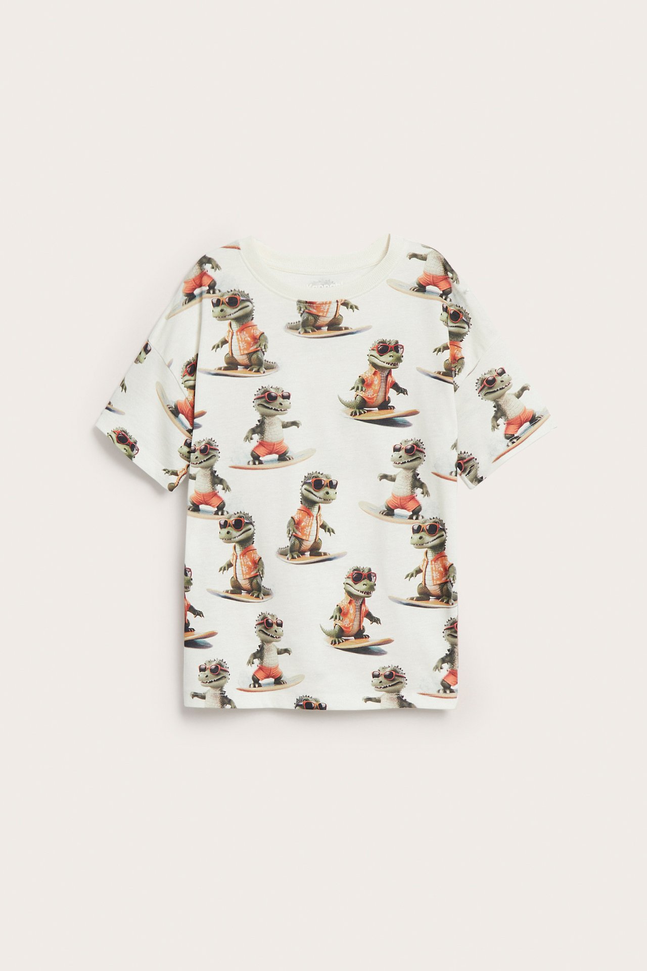 Off-white bomulls-t-shirt för barn med heltäckande mönster av surfande krokodiler, framifrån.