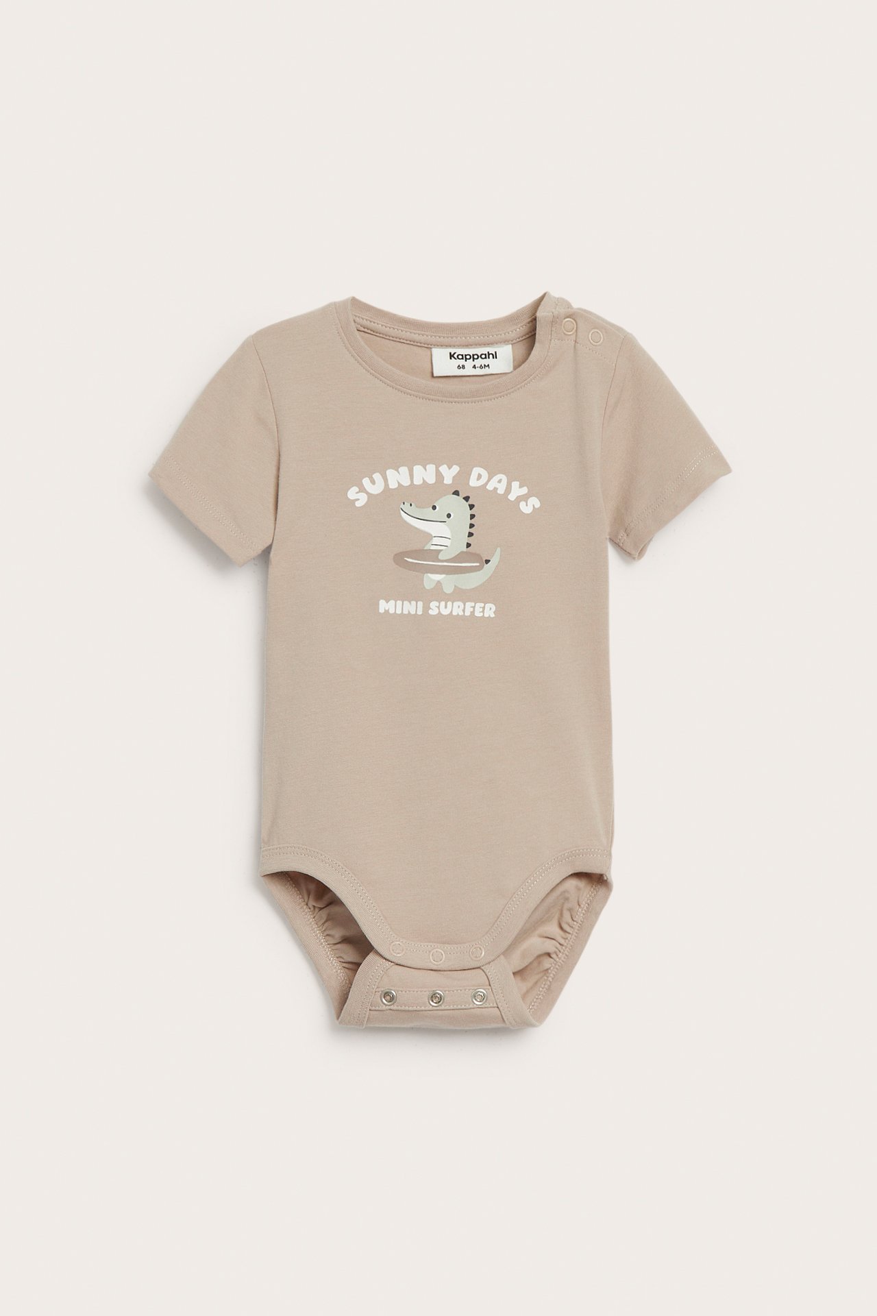 Edestä: beige lyhythihainen vauvan body krokotiiliprintillä ja neppareilla olkapäässä ja haarassa.