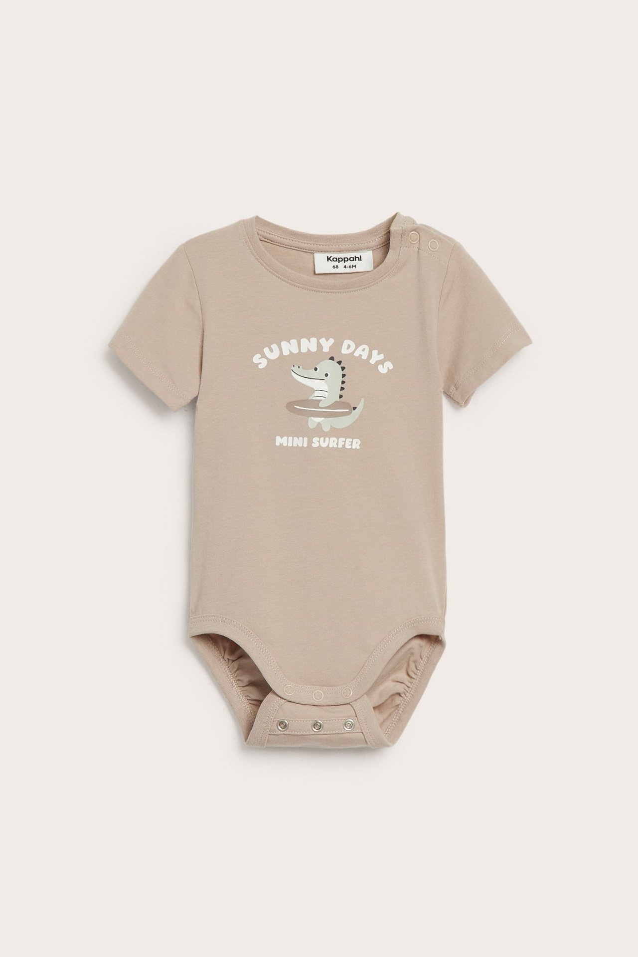 Widok z przodu: beżowe body niemowlęce z krótkim rękawem, nadrukiem krokodyla i zatrzaskami na ramieniu i w kroku.