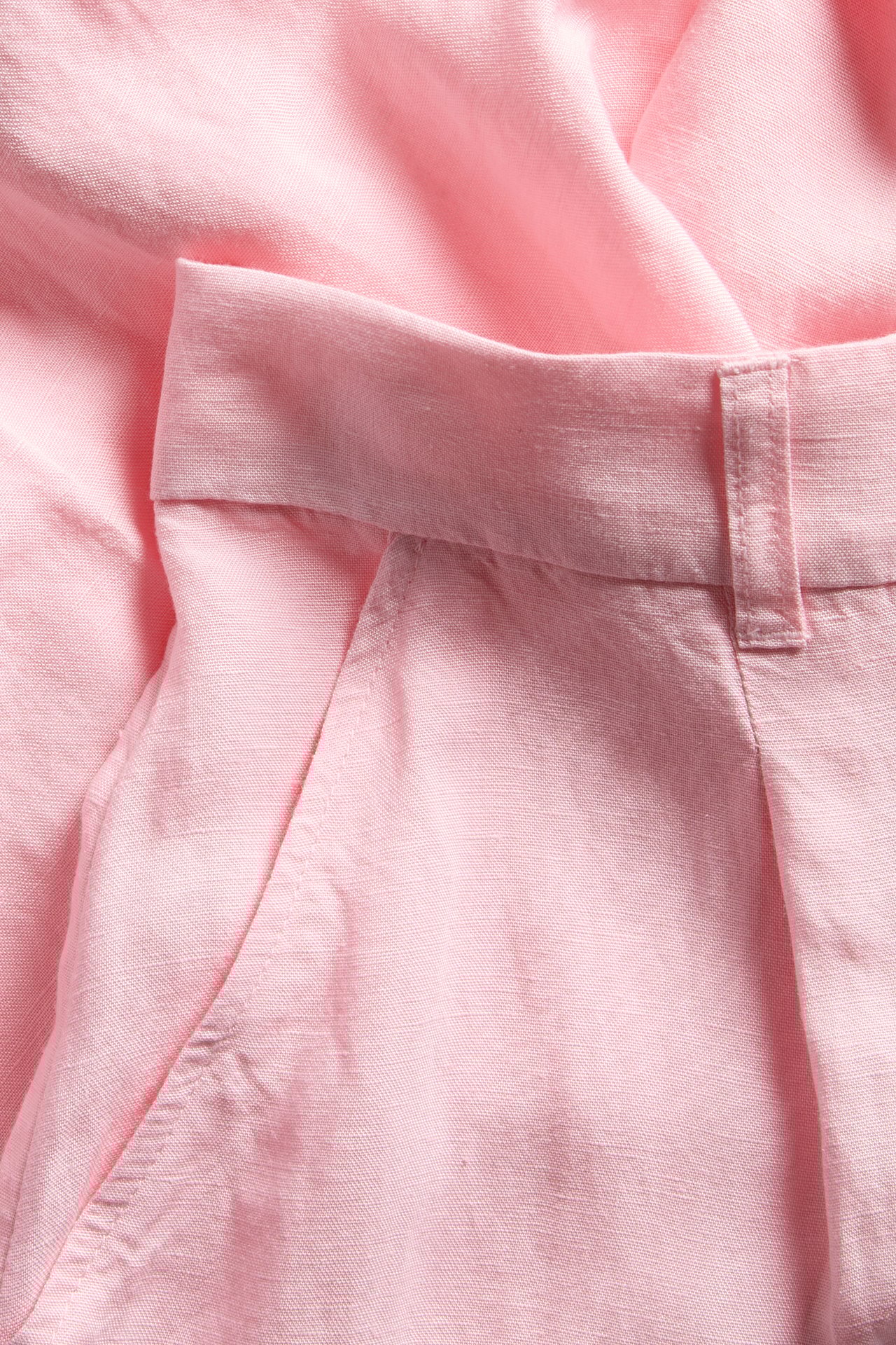 Nærbilde av rosa linblanding-shorts med elastisk midje, frontlommer og beltehemper.