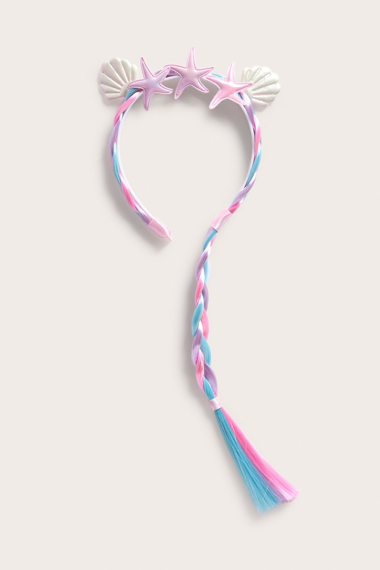 Framifrån: rosa diadem med flätat ljusrosa, blått, lila löshår, dekorerat med sjöstjärnor och snäckor.