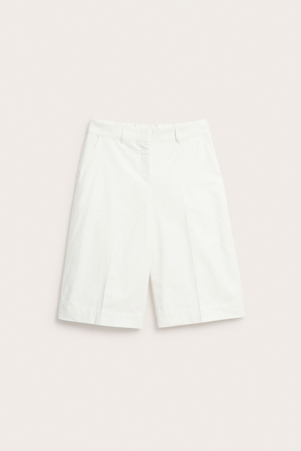 Edestä valkoiset puuvilla-pellavasekoitteiset Bermuda-shortsit sivutaskuilla ja vyölenkeillä.