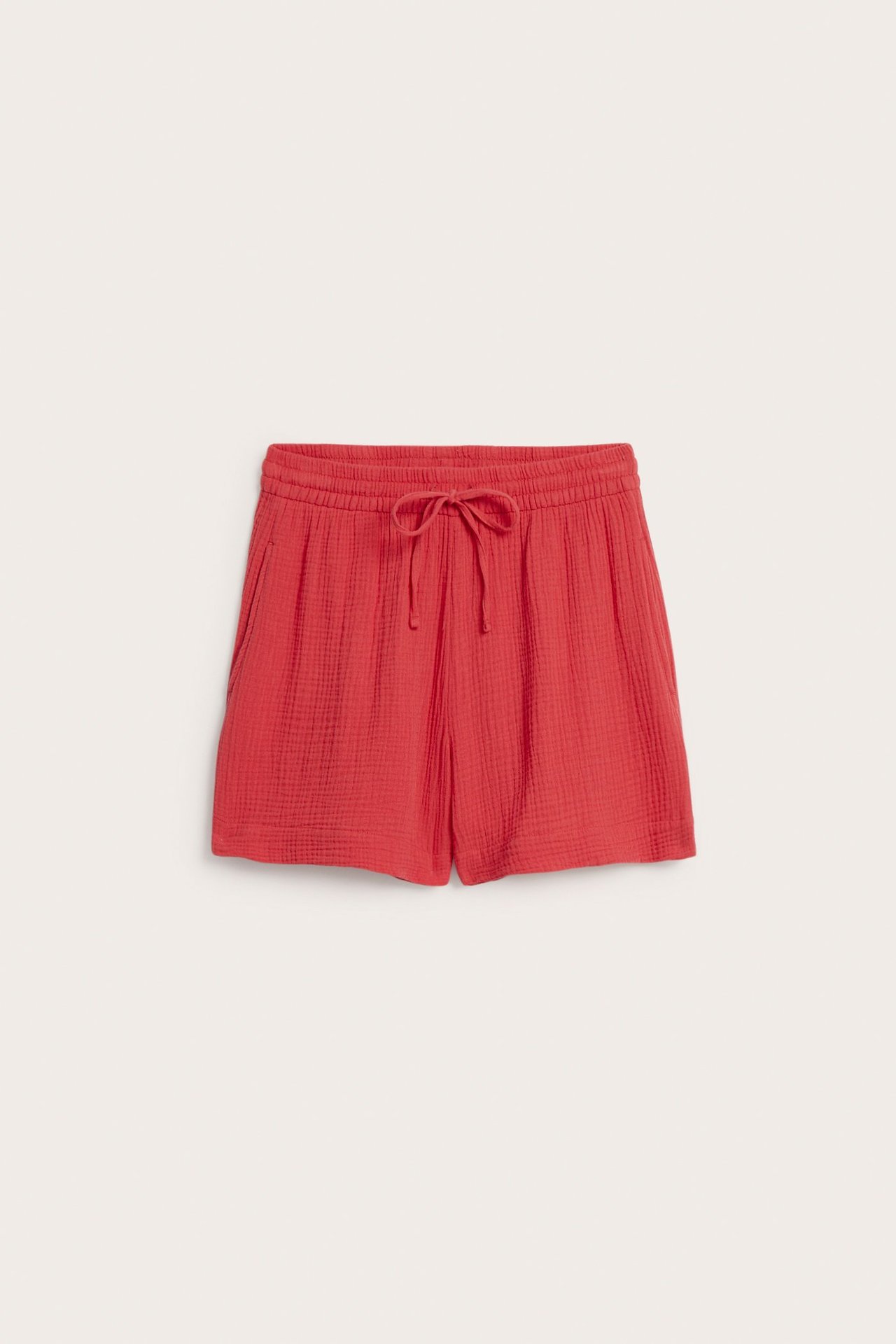 Frontvy av röda vävda bomullsshorts med resårlinning, dragsko och sidfickor.