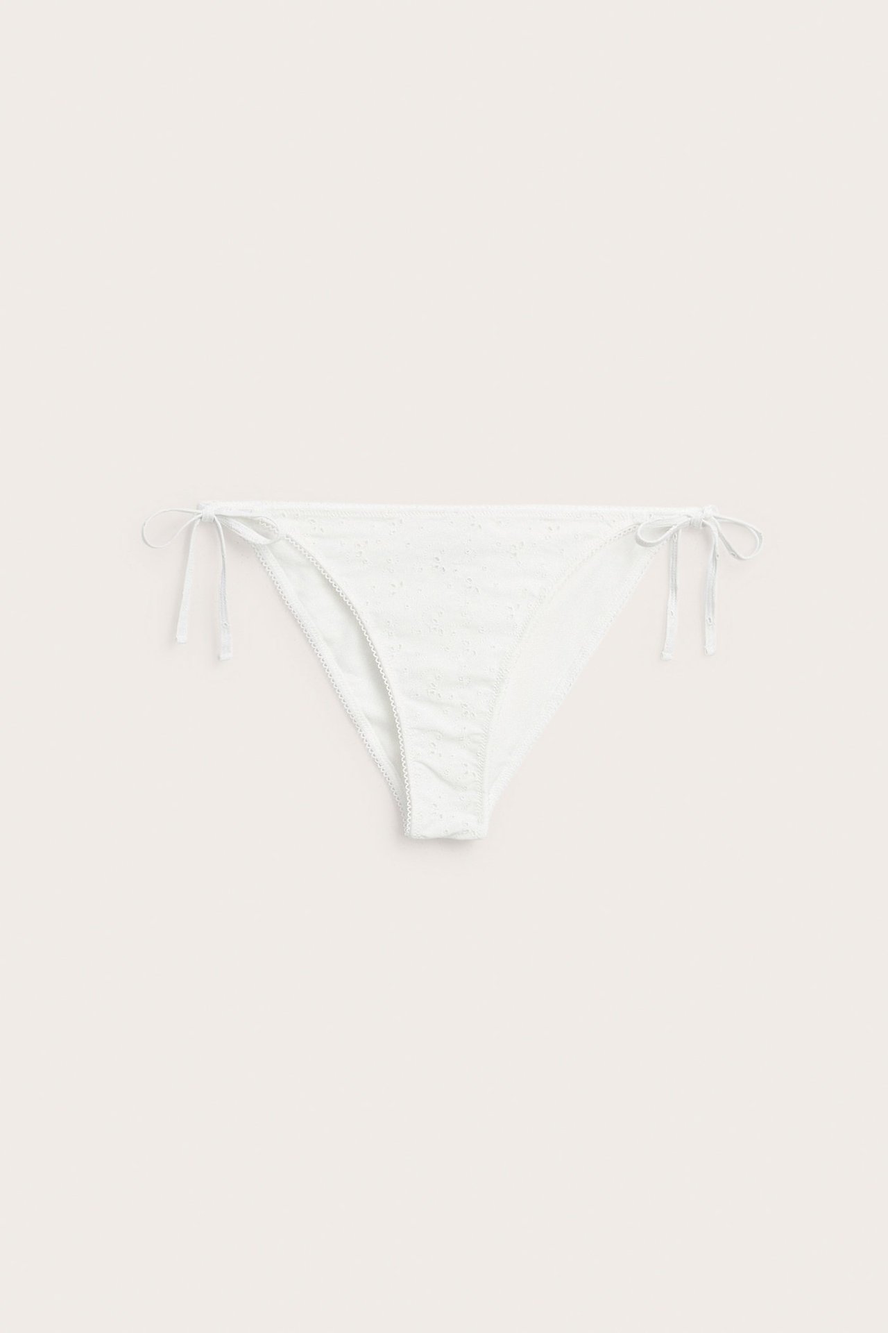 Z przodu: off-white dół od bikini damskiego, z haftem i wiązaniami po bokach.