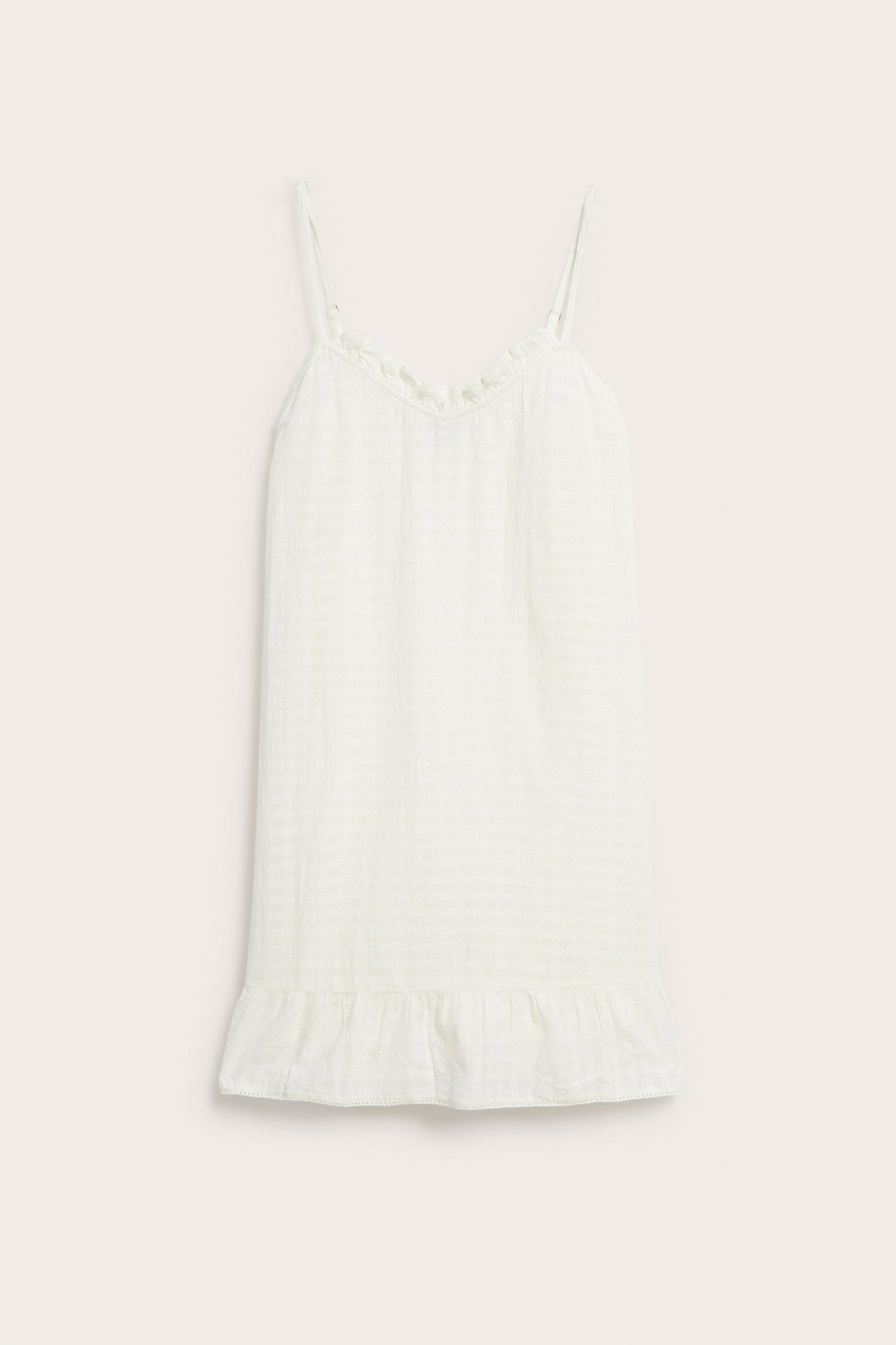 Frontvisning: Offwhite nattkjole i strukturvevd bomull med justerbare stropper og volangdetaljer.