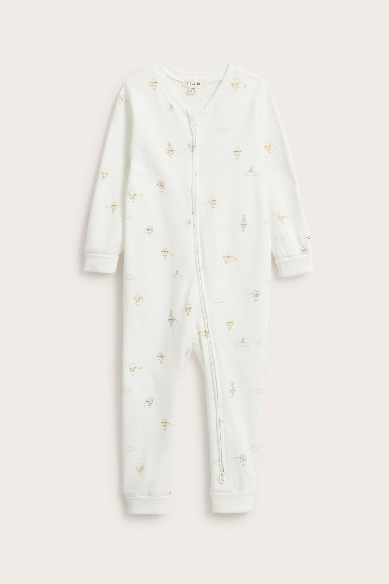 Widok z przodu: Biały bawełniany pajacyk dla niemowląt z wzorem w balony i zamkiem z przodu.