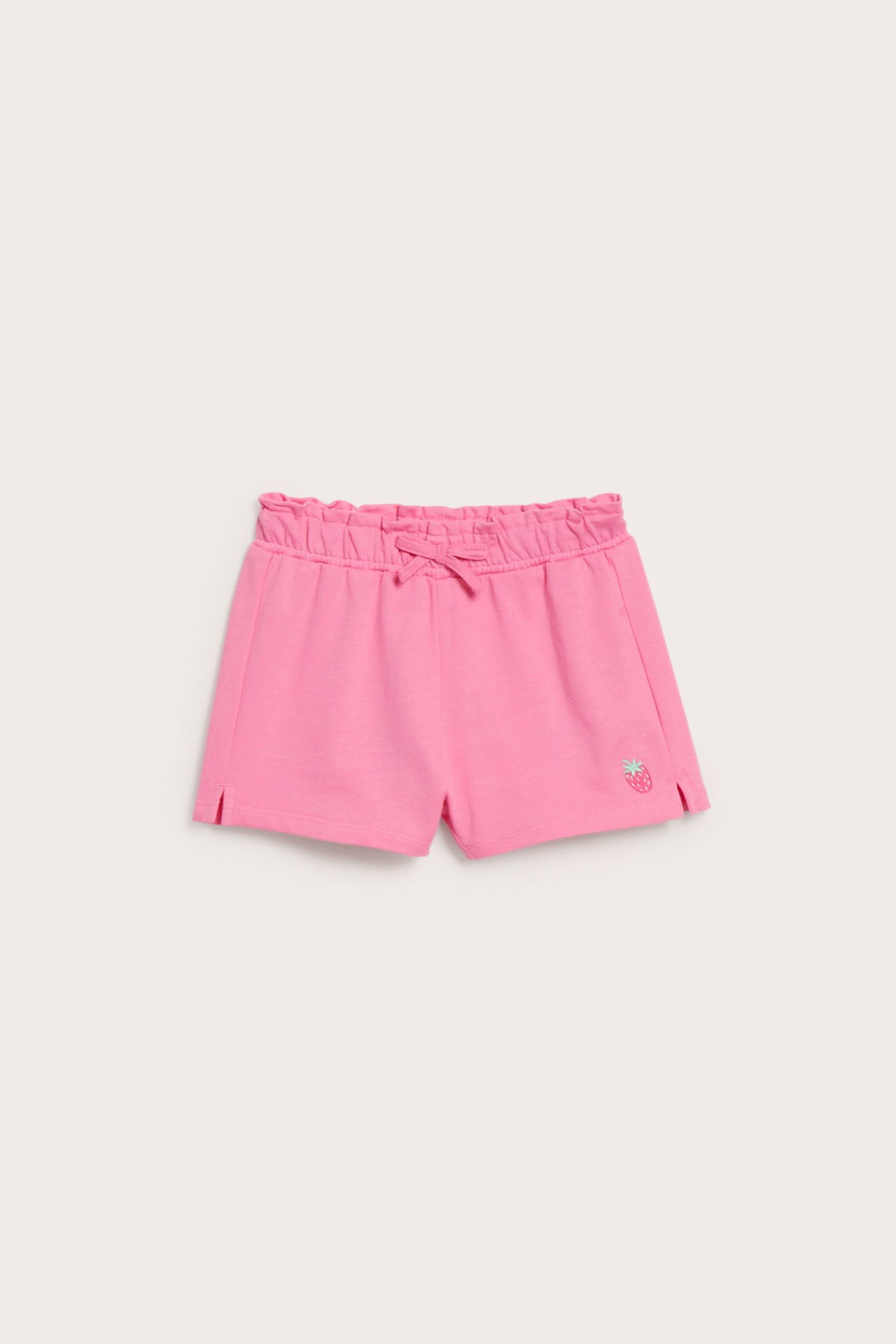 Rosa barneshorts i bomull med elastisk volangkant, sløyfe og brodert jordbær. Forfra.