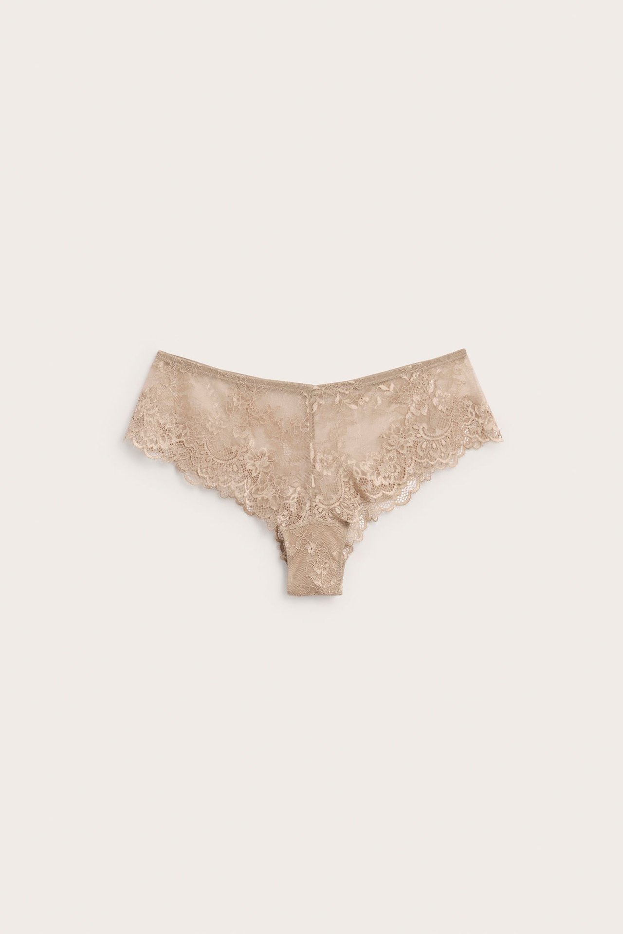 Edestä kuvattu beige pitsinen cheeky-alushousu V-muotoisella joustovyötäröllä.