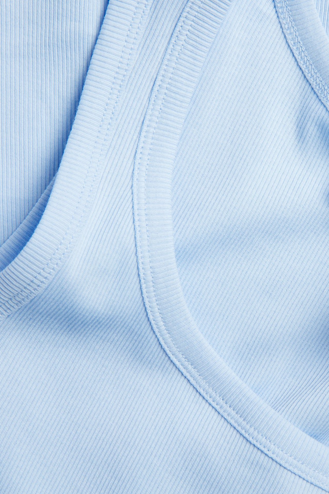 Lähikuva vaaleansinisestä ribbitoppista, jossa on kapea ribbirakenne pääntien alueella.