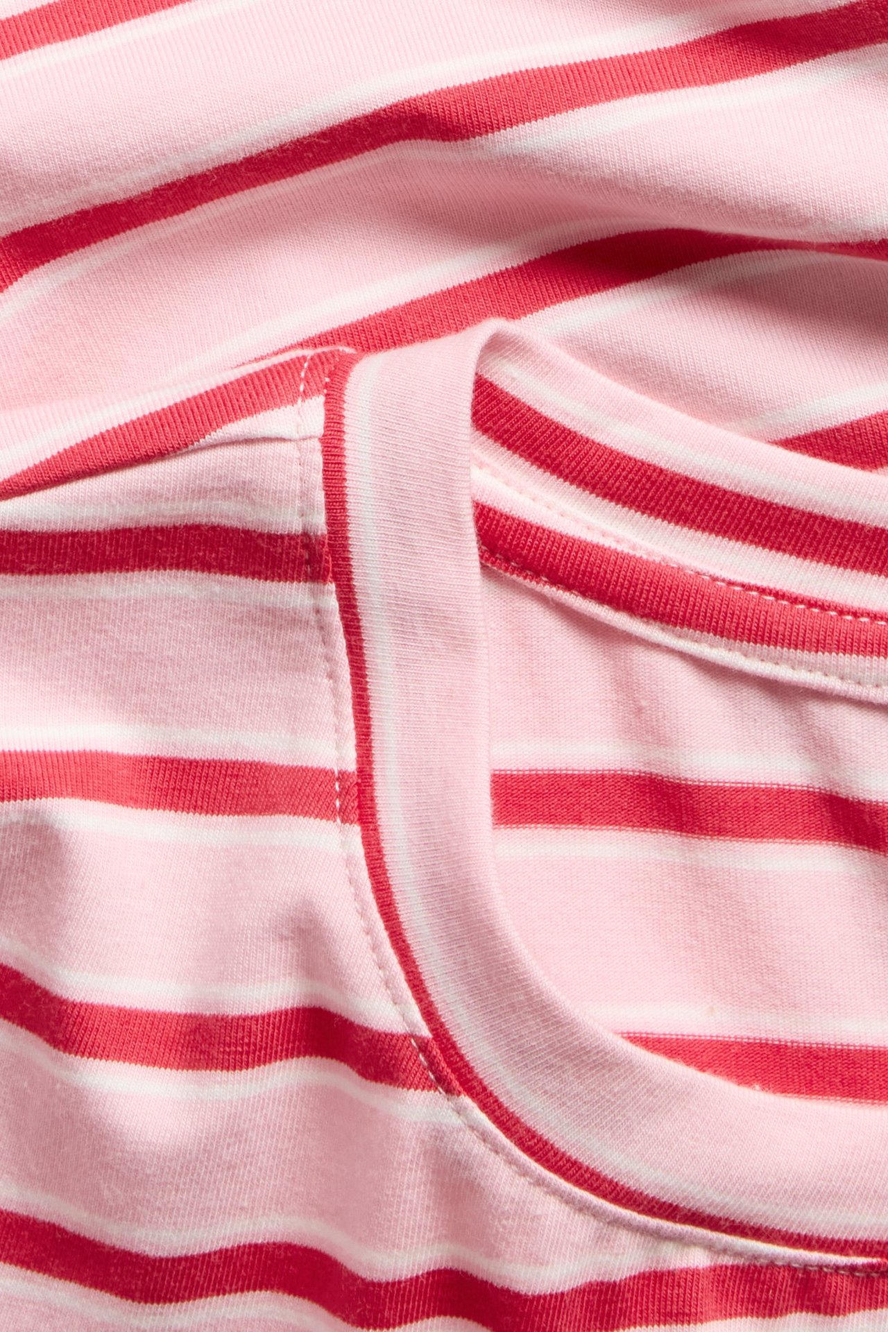 Zbliżenie różowo-czerwonego, dopasowanego, bawełnianego t-shirtu w paski z okrągłym dekoltem.