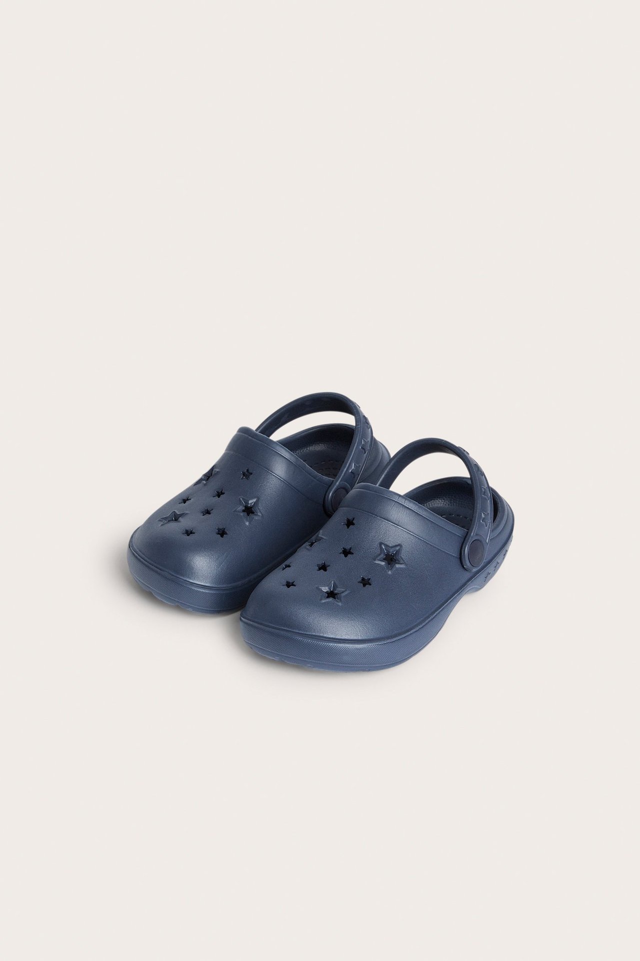 Edestä tummansiniset muoviset puukengät tähtileikkauksin ja joustavalla kantaremmillä.