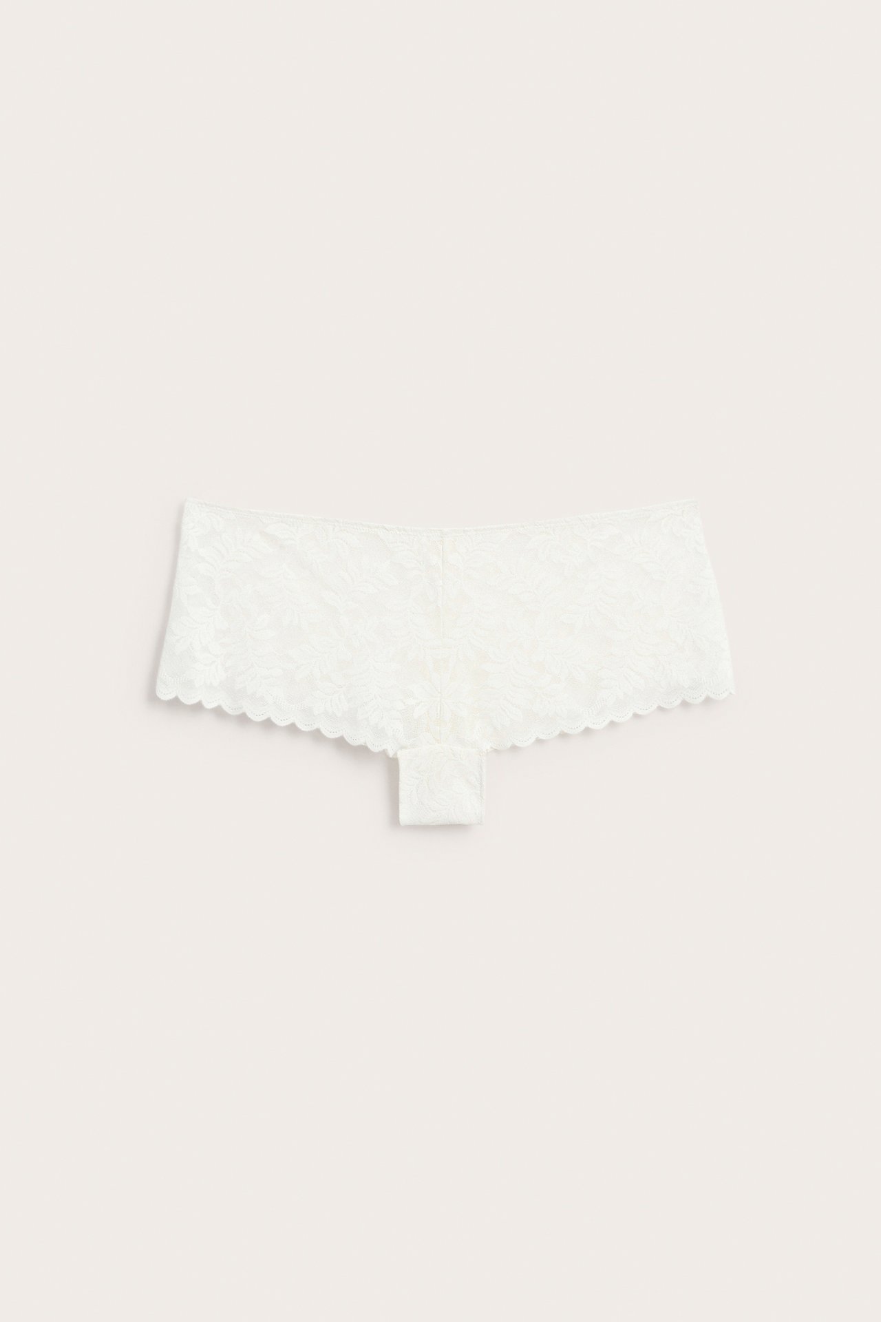 Framifrån, vita boy shorts i spets med vågig kant.