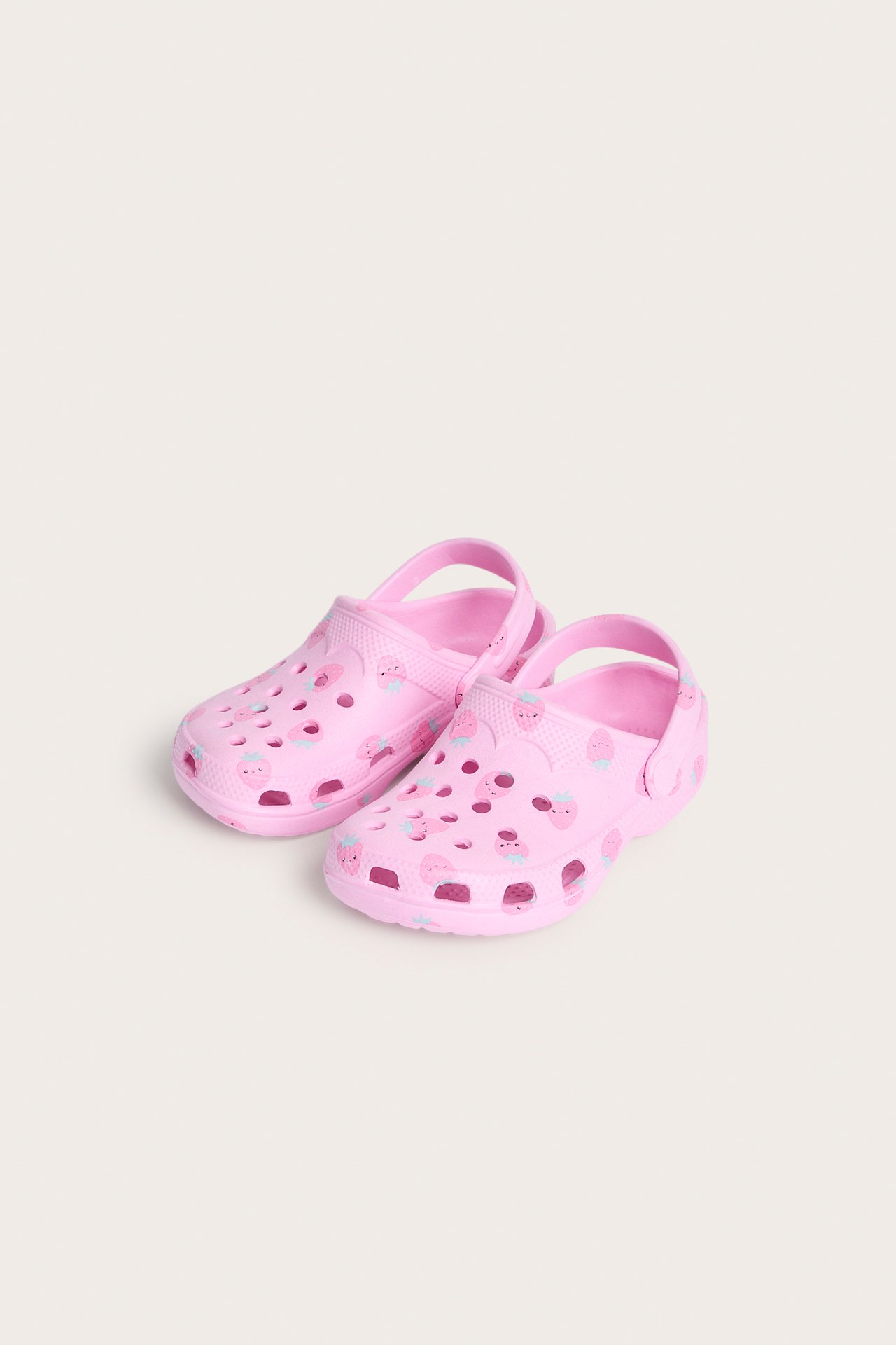 Edestä, vaaleanpunaiset lasten muoviklogit mansikkaprintillä ja rei'illä.