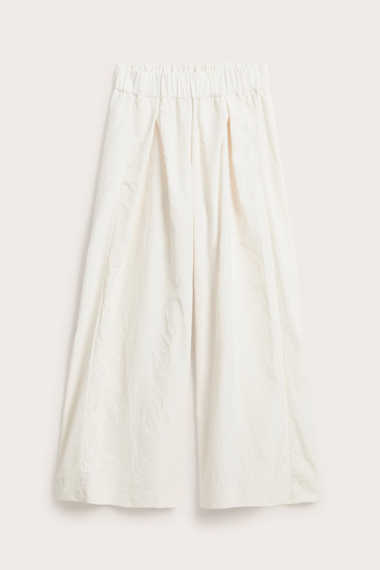Forfra hvite vide pull-on-bukser med strikk i midjen, frontfolder og teksturert stoff.