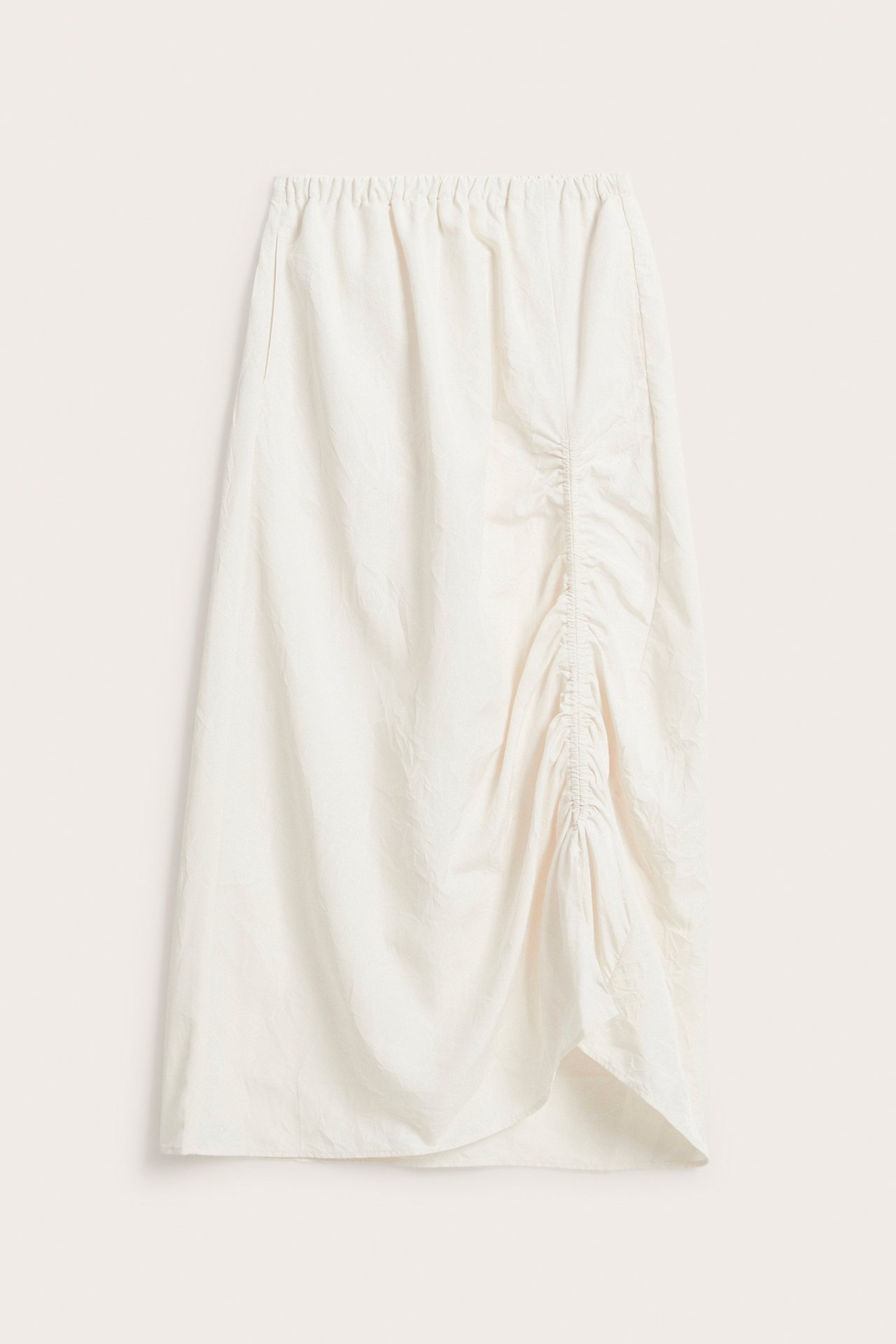 Frontbilde av hvitt skjørt i vevd polyester med elastisk midje og justerbar sidetrekning som skaper en asymmetrisk kant.