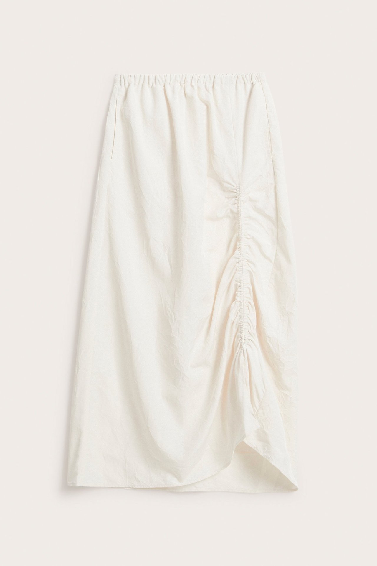 Framsida av vit kjol i vävd polyester med resår i midjan och justerbar sidosnörning som skapar asymmetrisk fåll.