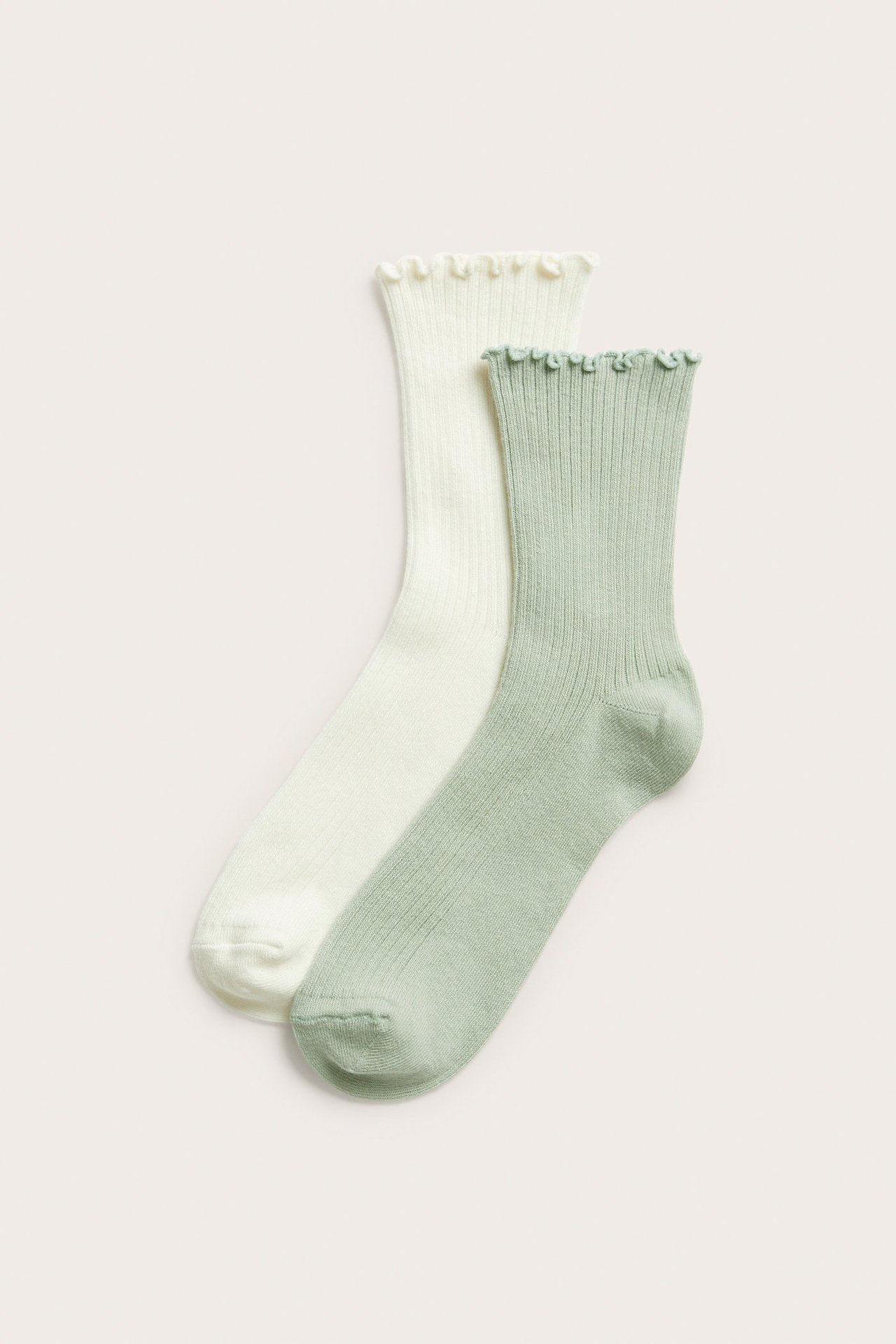 Platt lay av två ribbade strumpor, en ljusgrön och en benvit, båda med volangmudd.