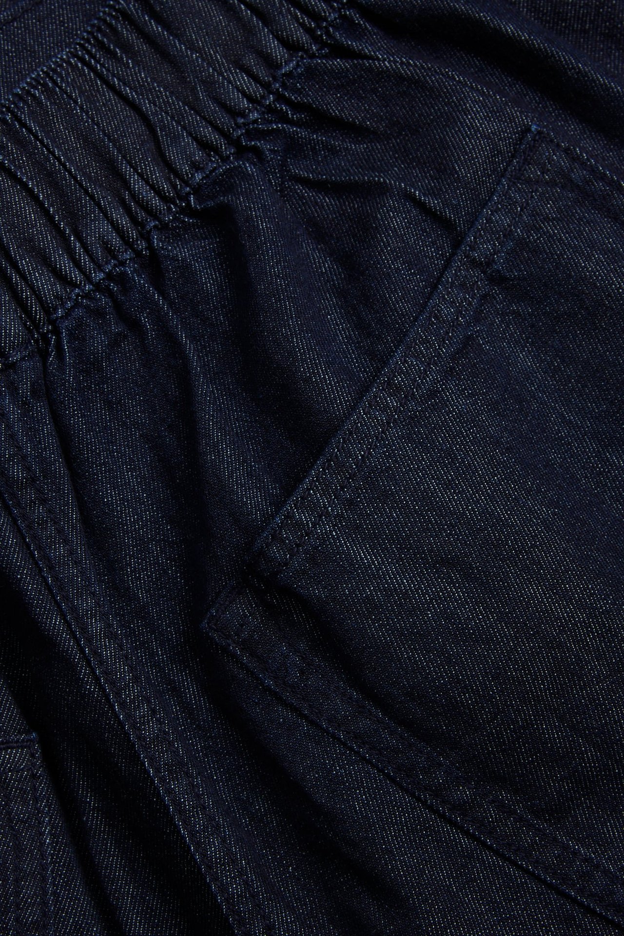 Lähikuva tummansinisistä denim culotte-farkuista, joissa on joustava vyötärö ja sivutasku.
