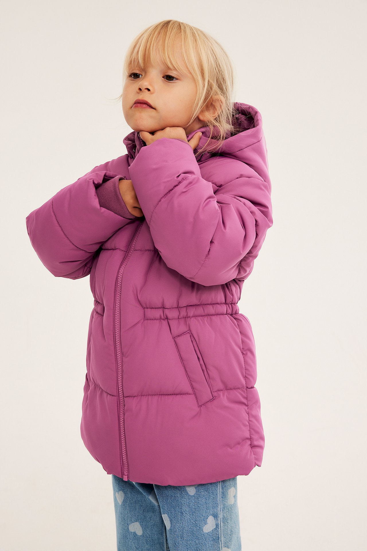Lilla dunjakke med hette og snøring i livet på barn med blå hjerte-jeans.