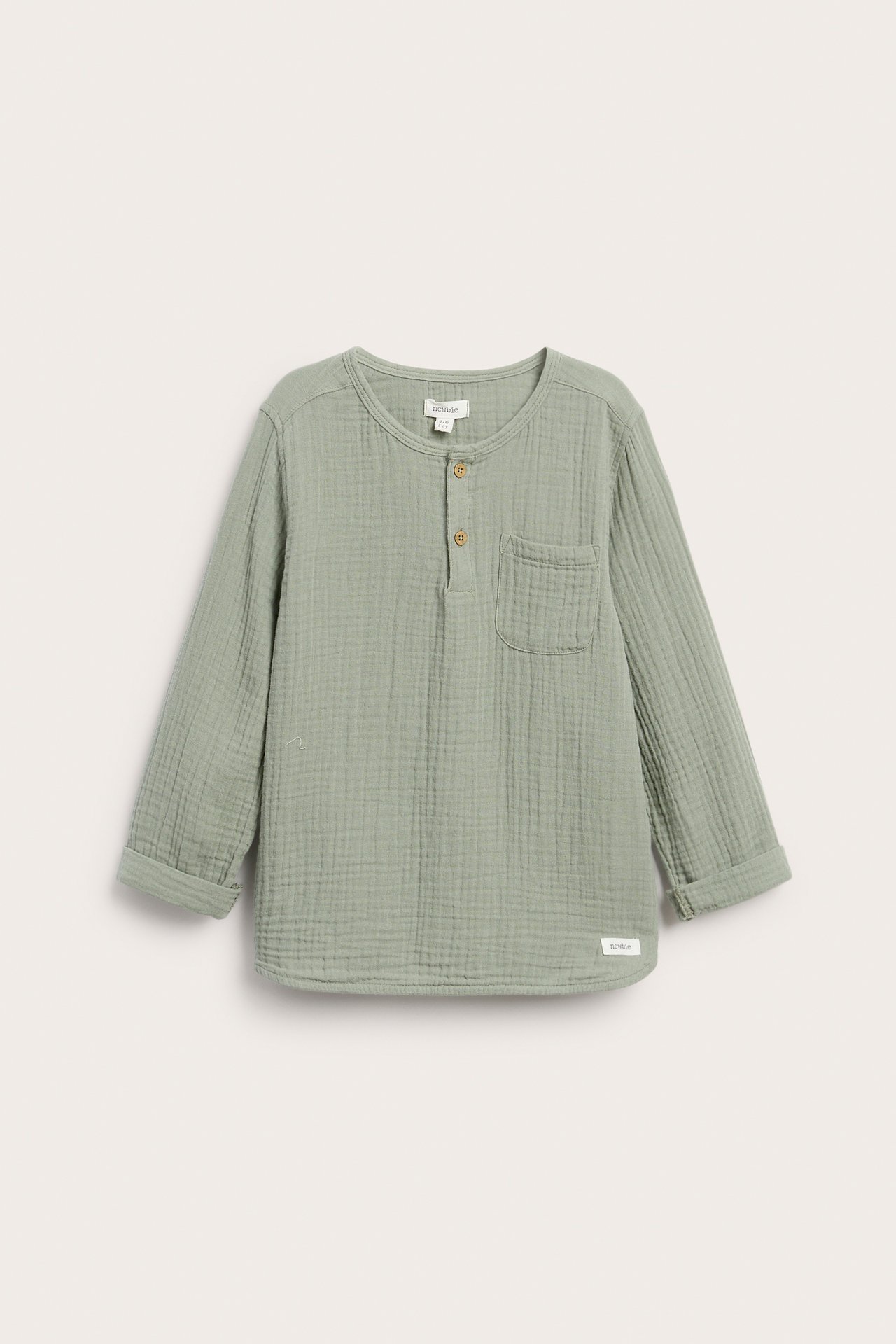 Widok z przodu: Dziecięcy ciemnozielony top z muślinu, guziki, kieszonka, podwinięte rękawy.