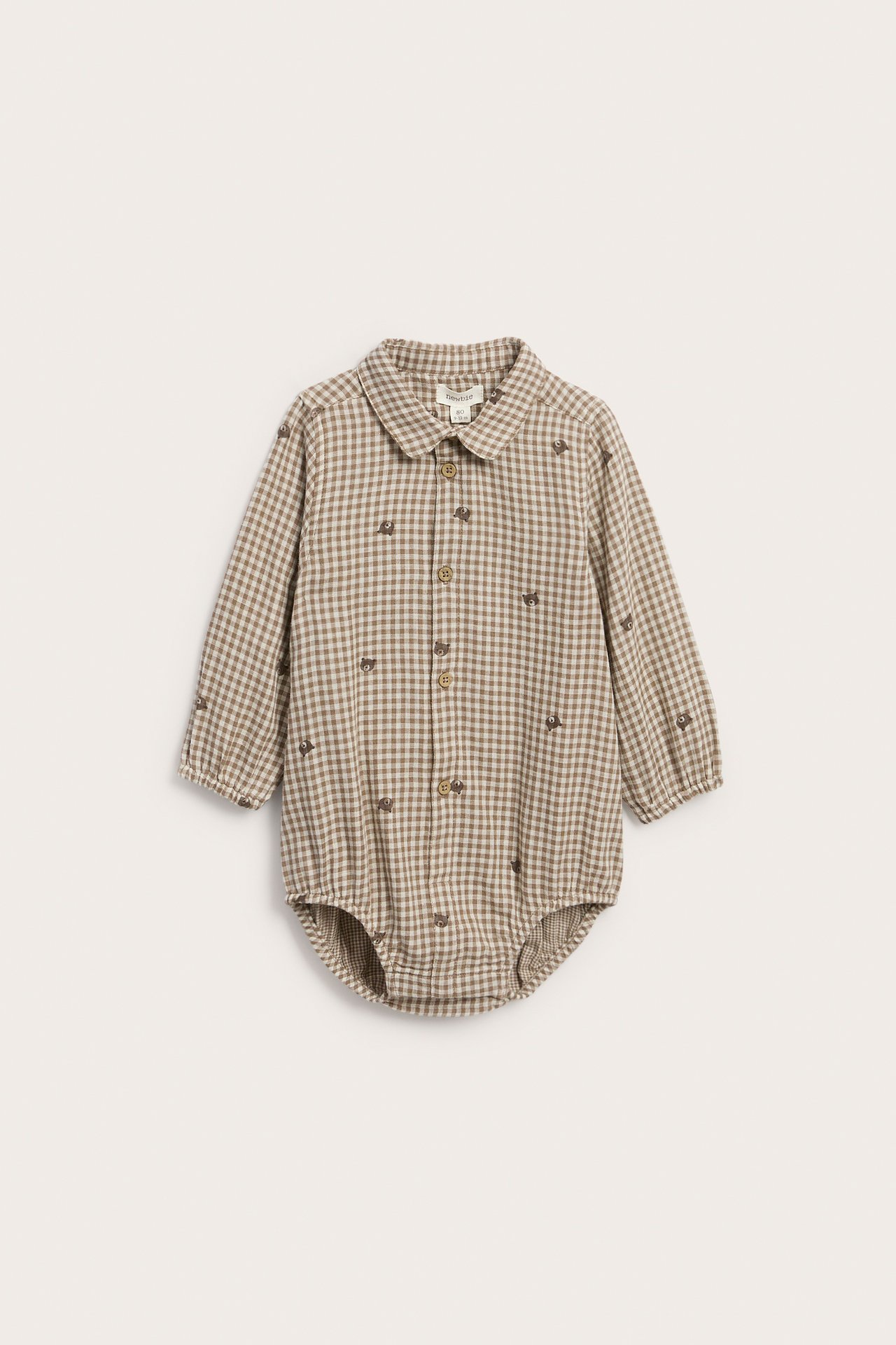 Edestä: vauvan pitkähihainen ruskea-beige ruudullinen potkupuku karhubrodeerauksella.