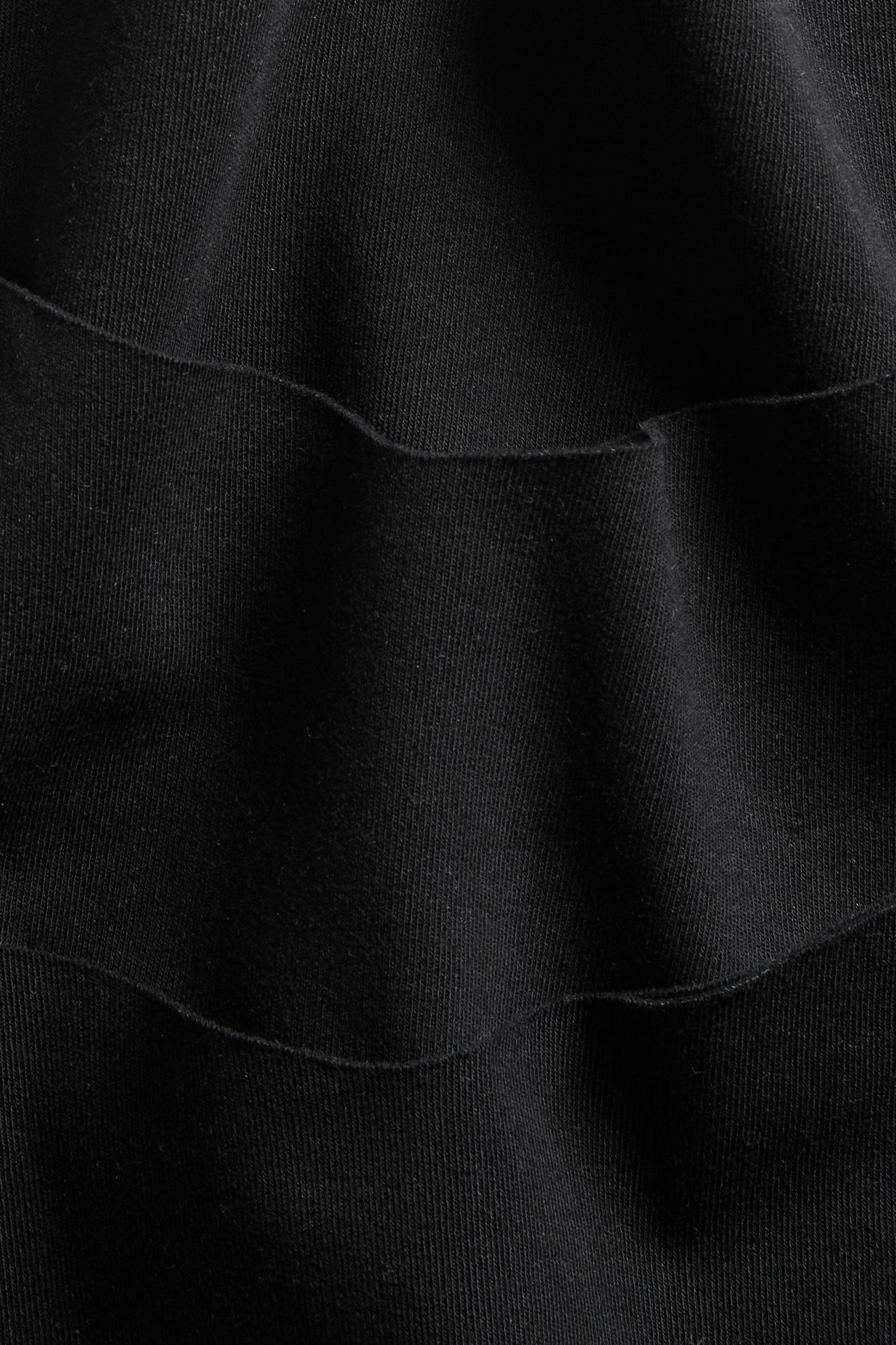 Nærbilde av svart, sømløst bomullsmiks stringstoff for dame med diskrete folder.